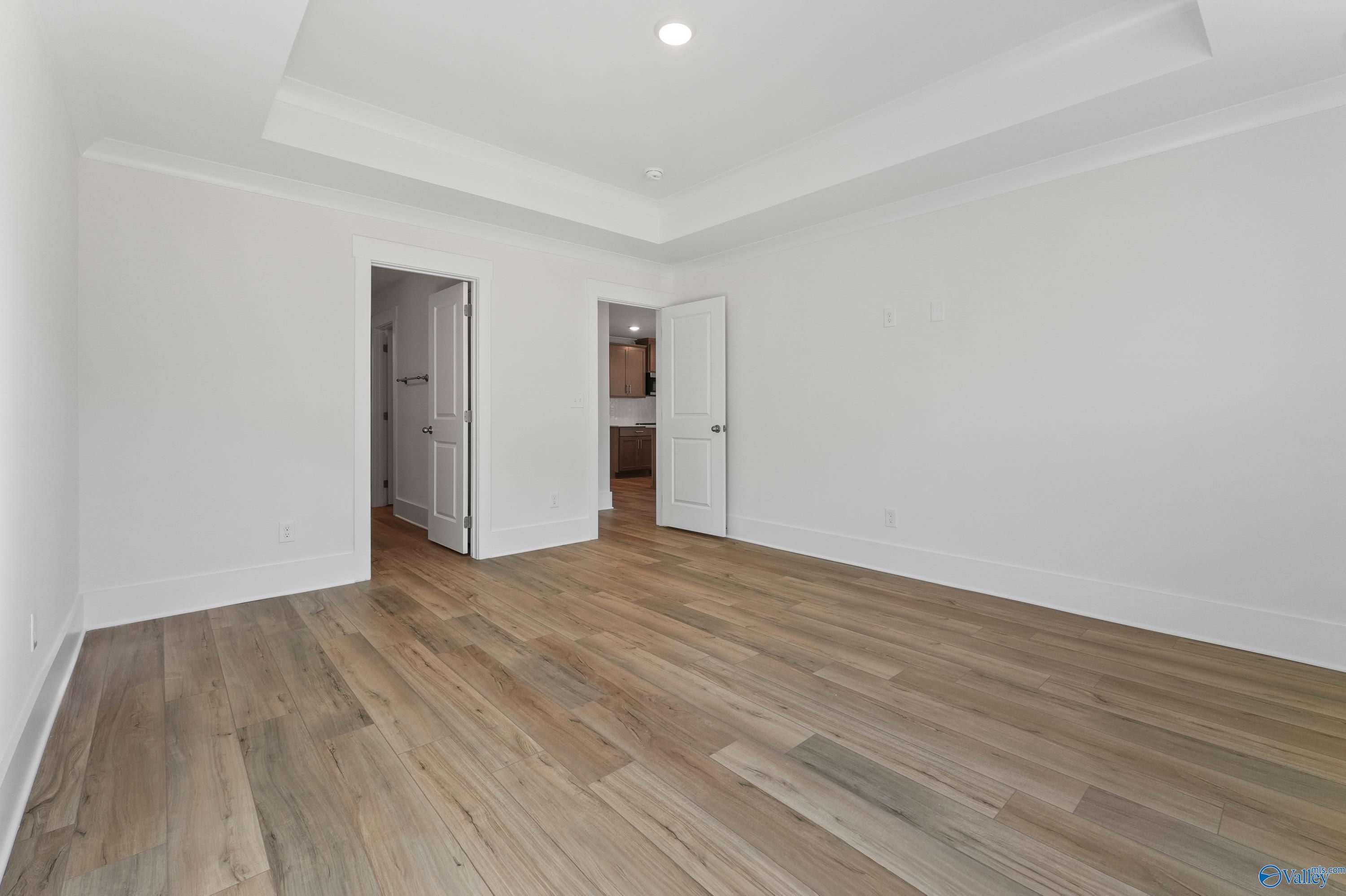 Bright master bathroom with white walls, hardwood floors, and open vanity in Davidson Homes The Daphne C, Arab, Alabama