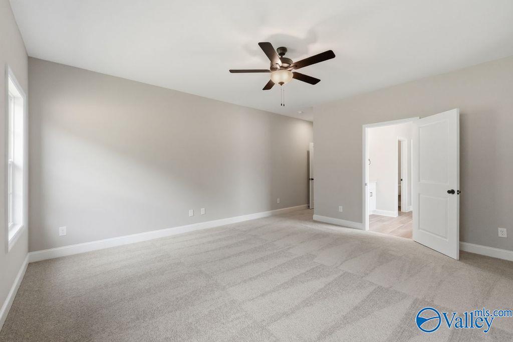 Spacious carpeted bedroom with ceiling fan in The Rockford floor plan at Cain Park, Hartselle, Alabama.