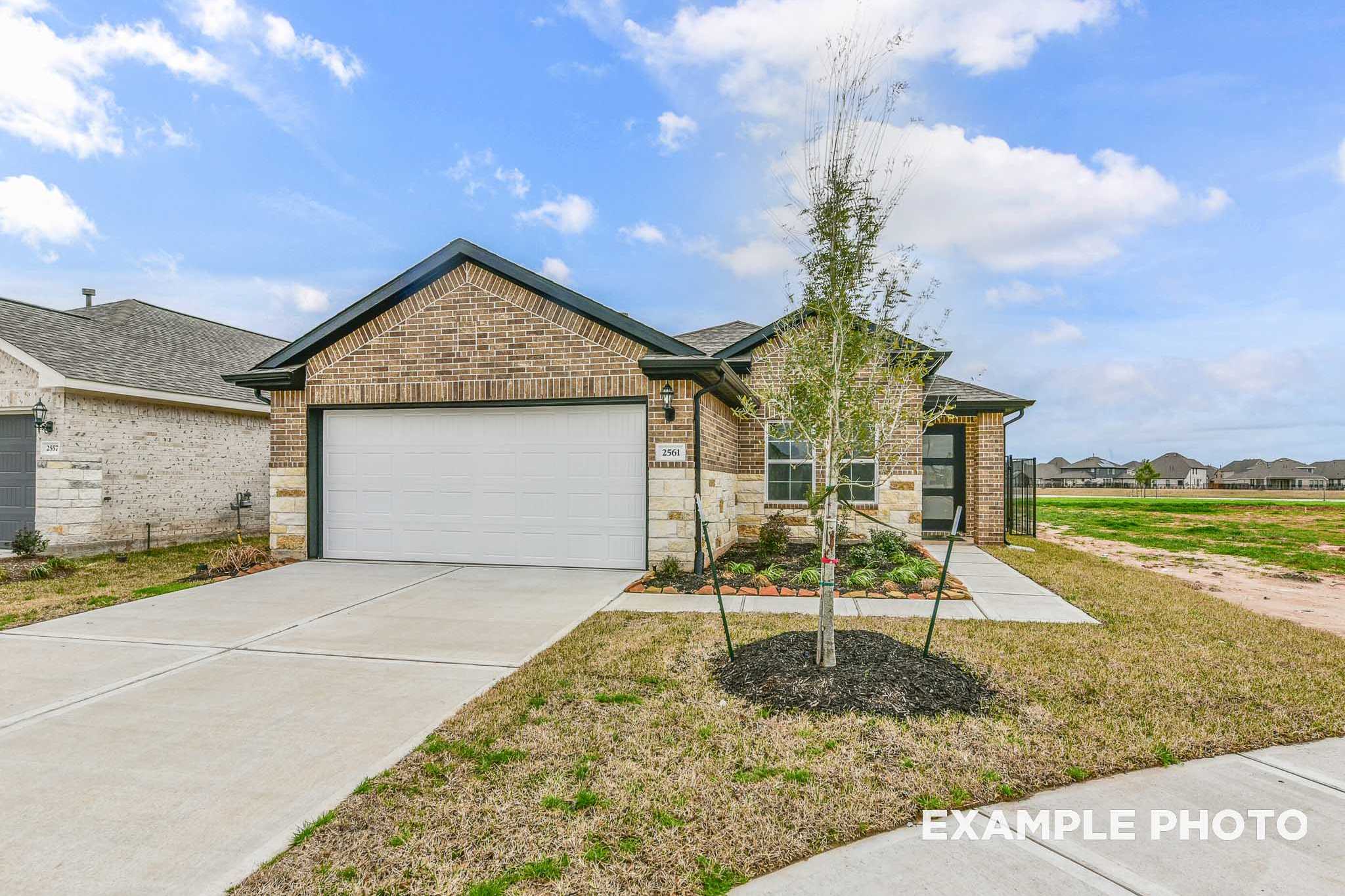 Modern single-story elevation of The Costa B showcasing brick exterior, two-car garage, and landscaped front yard in Beasley, Texas