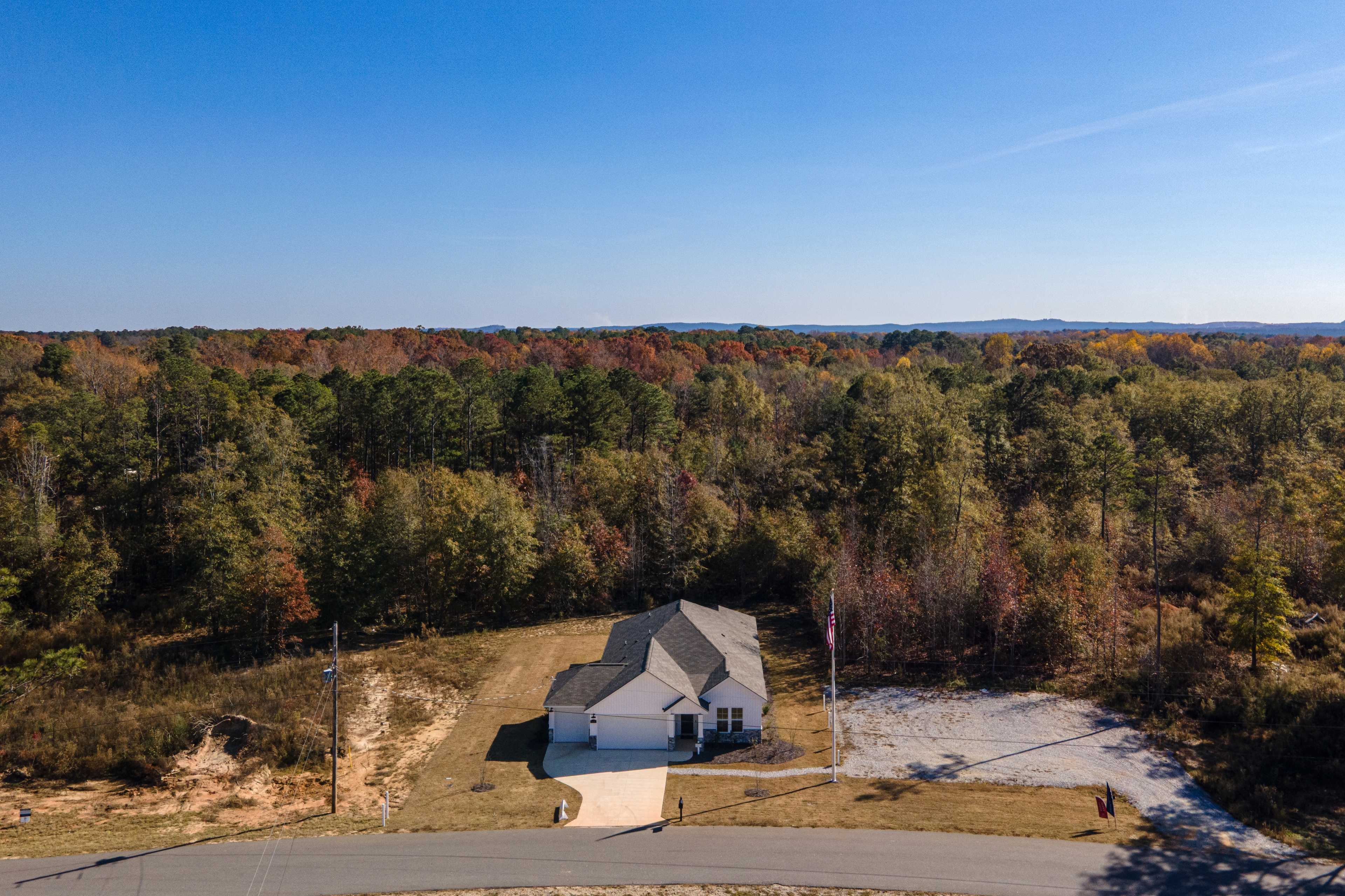 Aerial view of modern single-story home at Silver Oak in Cusseta Alabama with wooded surroundings