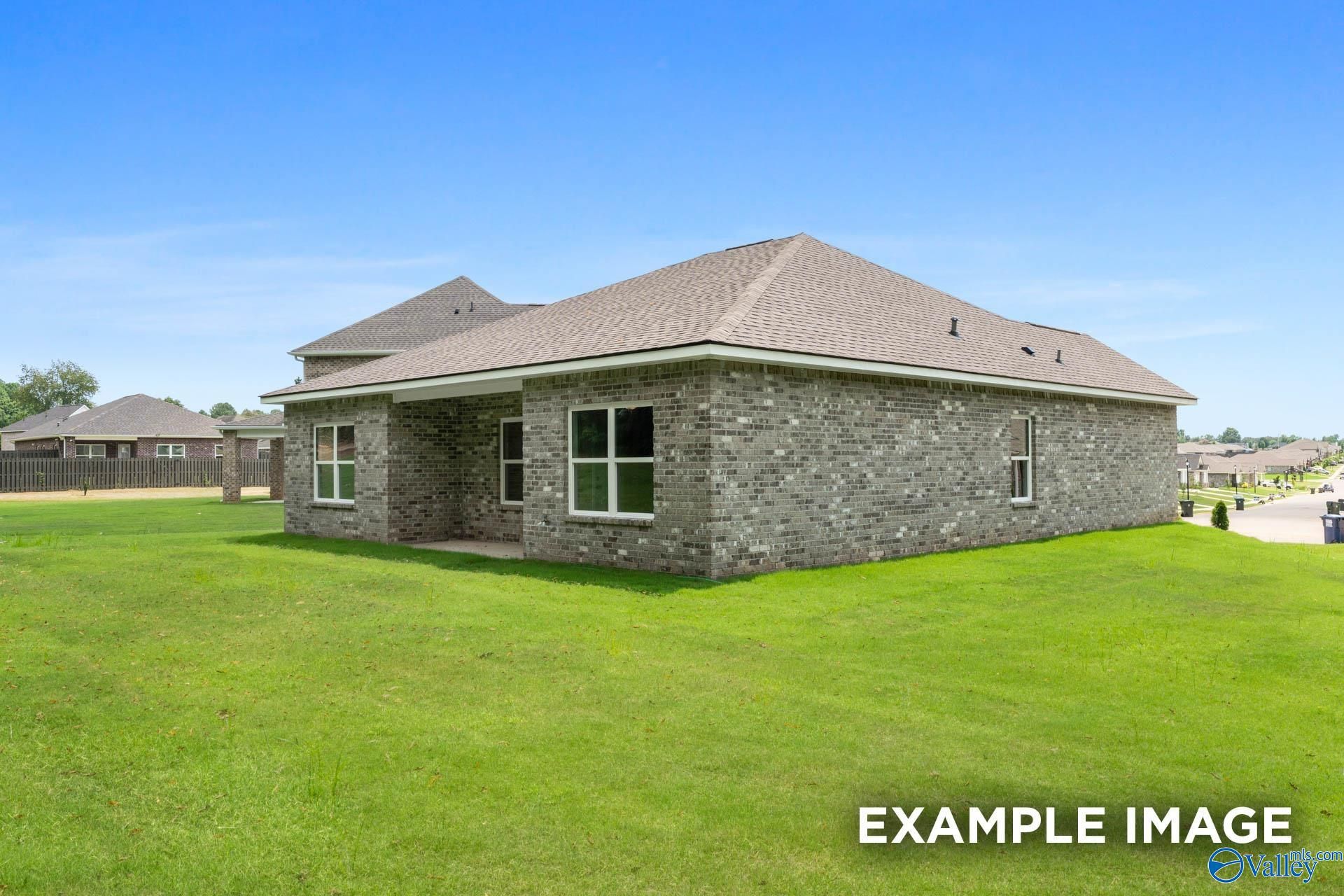 Brick single-story home with stone accents, gabled roof, front porch, and green lawn in Clearview, Hazel Green, Alabama by Davidson Homes