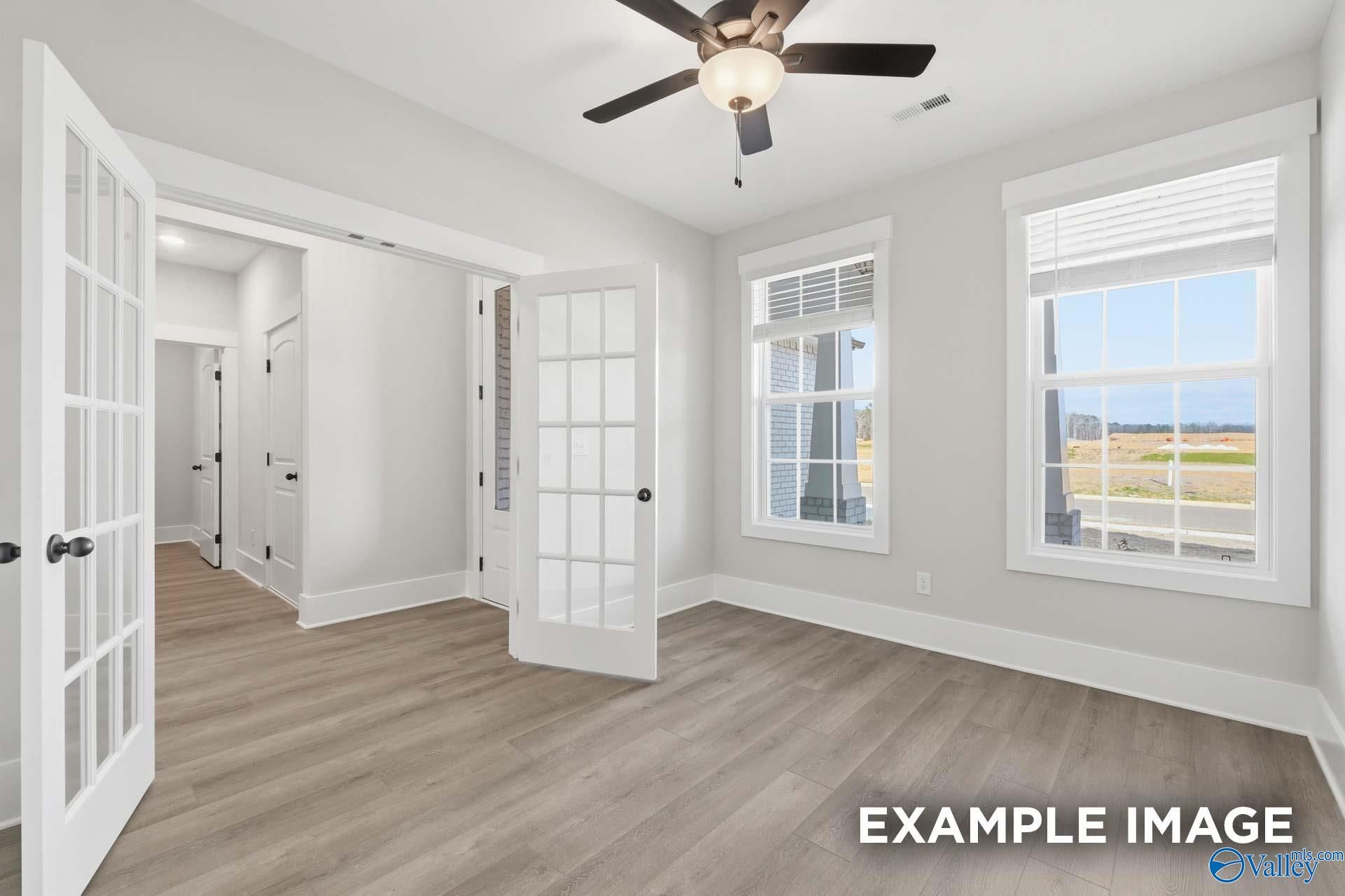Bright home office or flex room with French doors and wood-look flooring in The Rockford floor plan, Meridianville, AL.