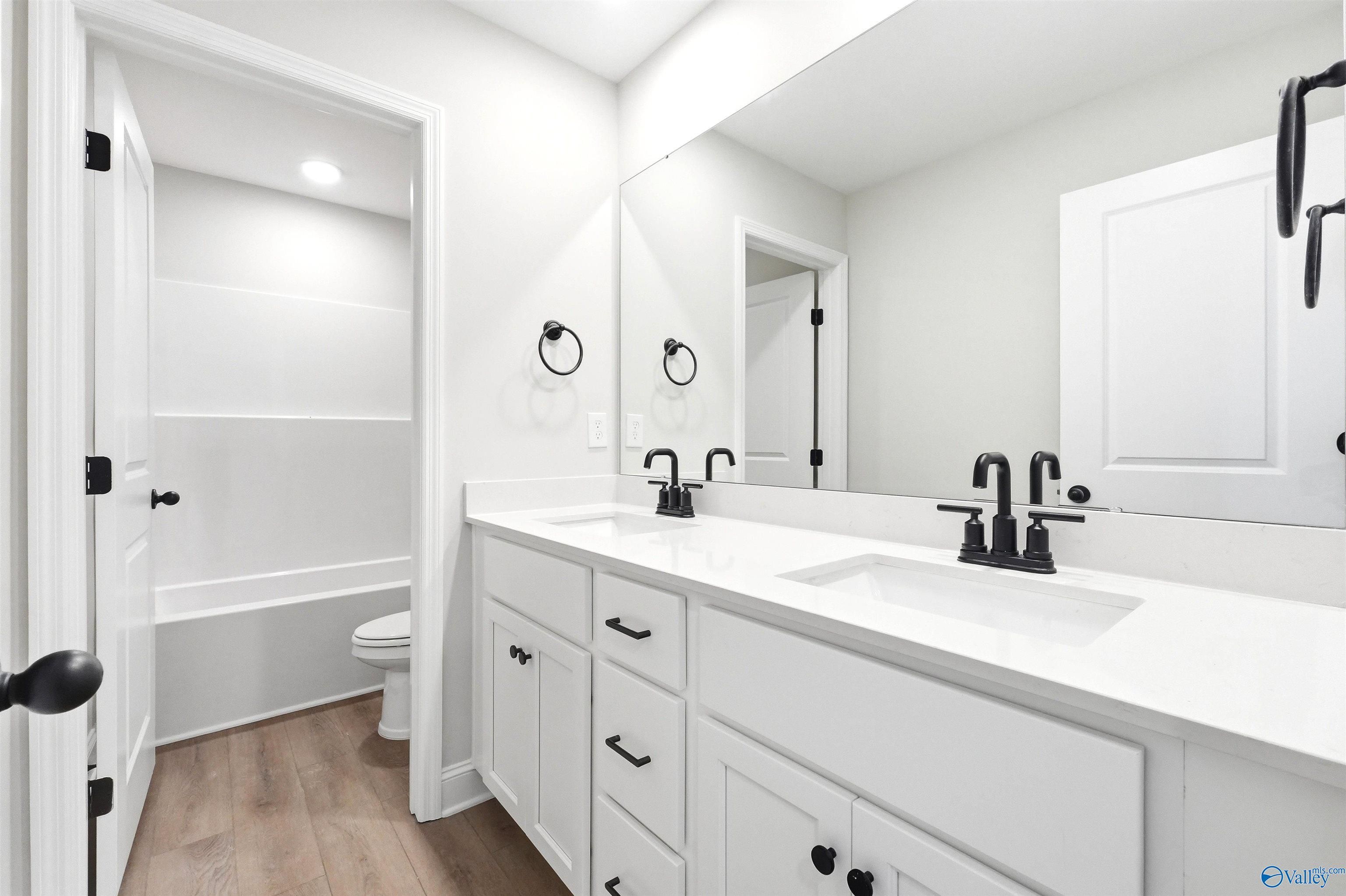 Modern bathroom with double vanity and matte black fixtures in The Chelsea D floor plan at Berry Cove, New Market, Alabama.