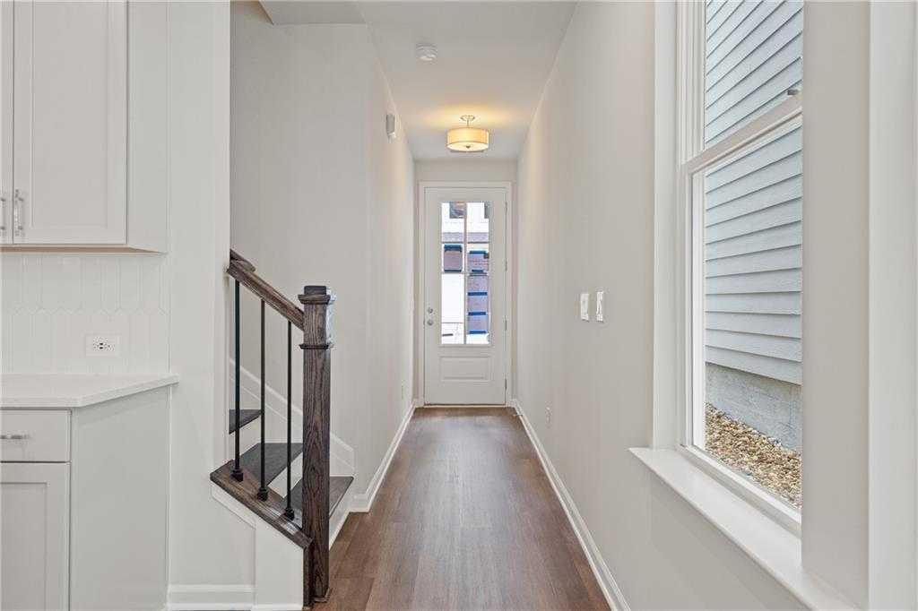 Bright entry hallway with oak staircase and white cabinetry in Davidson Homes The Cary B, Kennesaw, Georgia