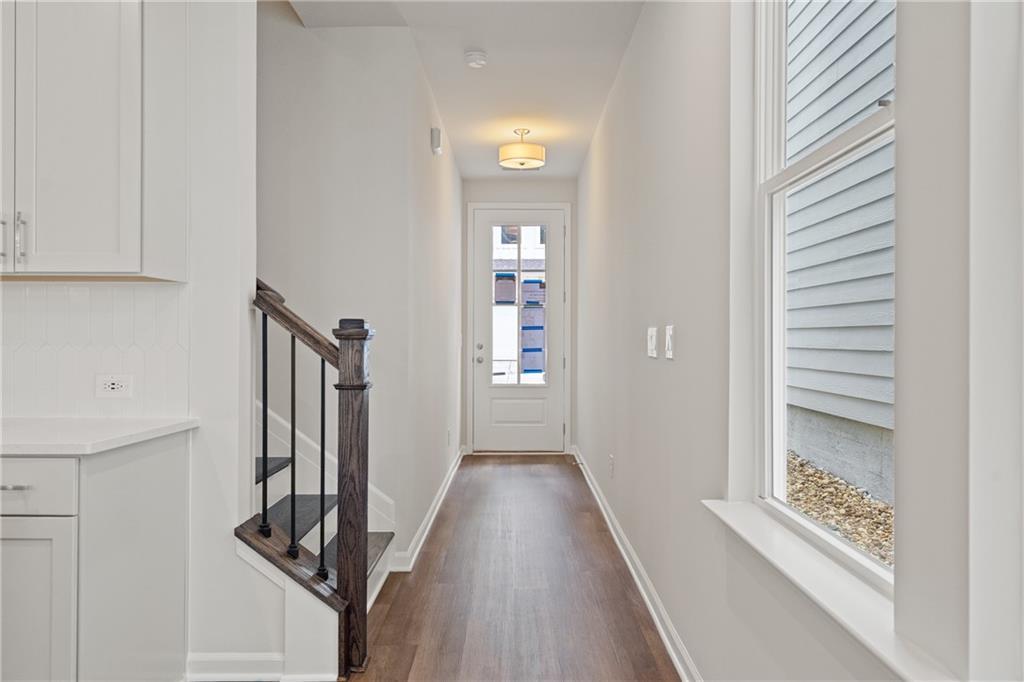 Bright entry hallway with oak staircase and white cabinetry in Davidson Homes The Cary B, Kennesaw, Georgia