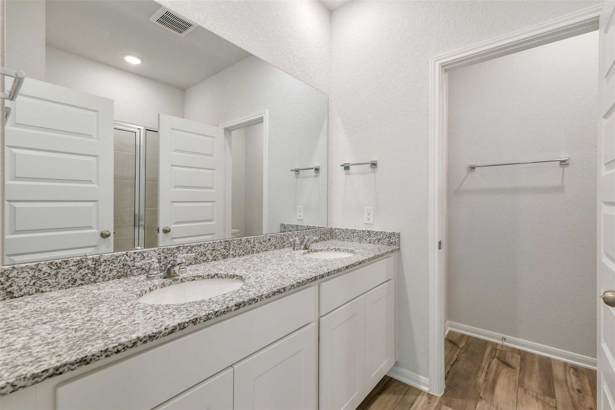 Modern double vanity with granite countertops and walk-in shower in Davidson Homes The Frio G, Conroe, Texas