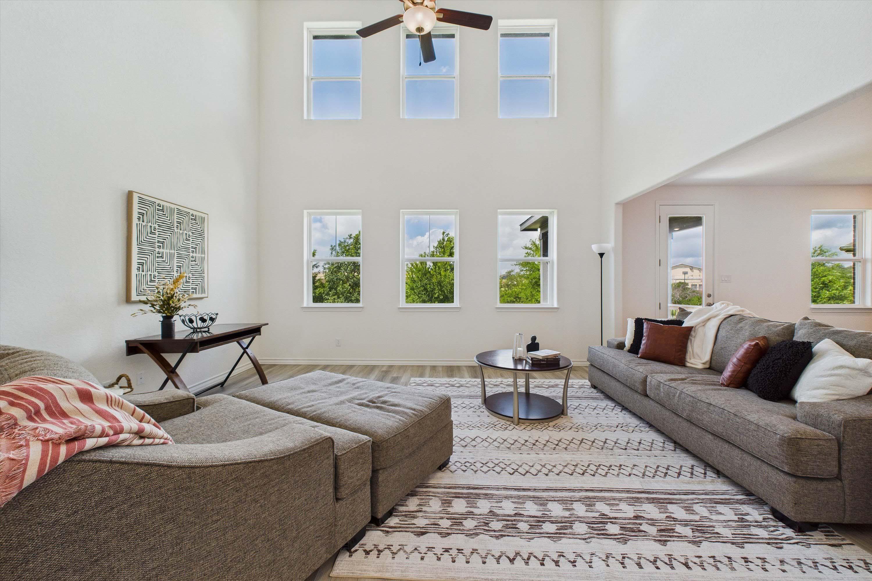 Spacious two-story living room in The Danbury featuring soaring ceilings, large windows, and modern open-concept design.