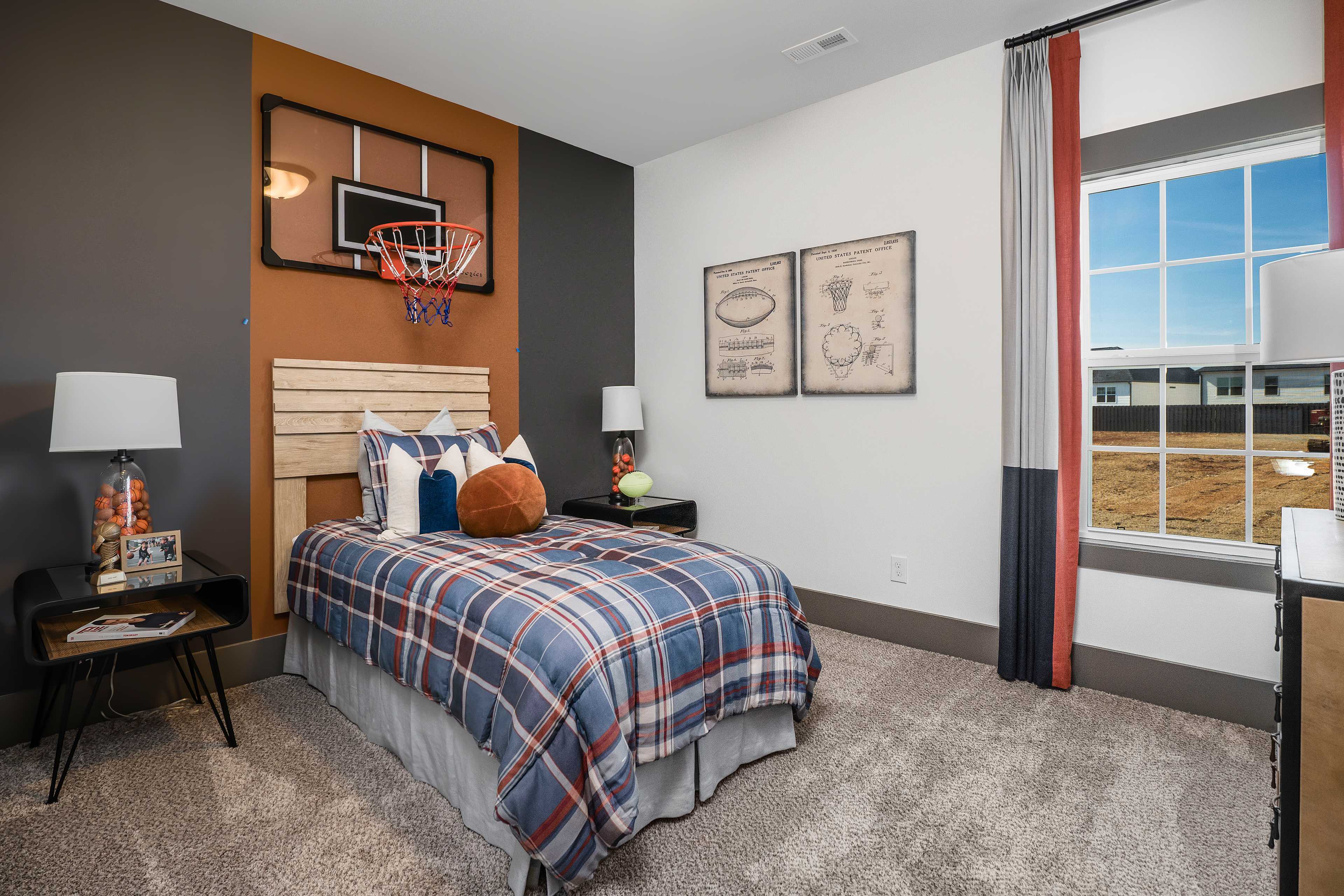 Basketball-themed boy's bedroom at Barnett's Crossing in Madison, Alabama with twin bed, plaid bedding and sports art