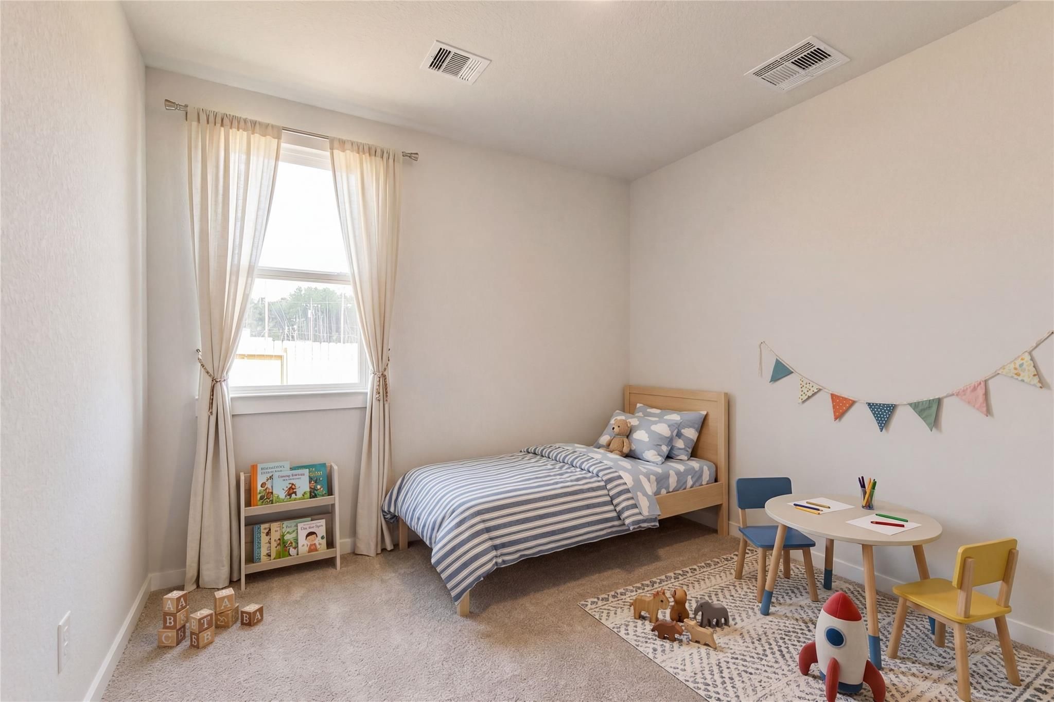 Cozy children's bedroom with twin bed, striped sheets, play table, toys and bookshelf in Davidson Homes The Frio G, Cleveland, Texas