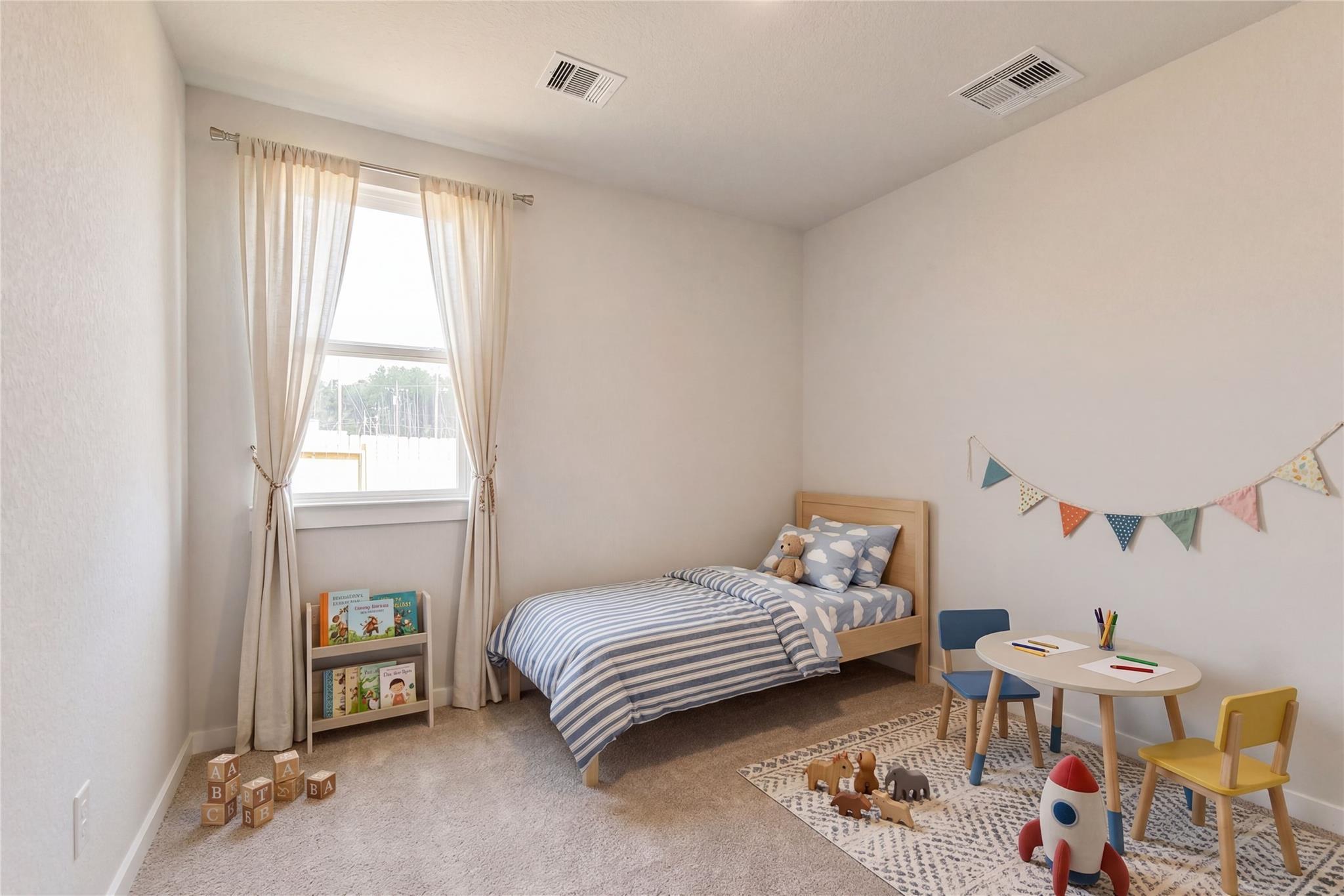Cozy children's bedroom with twin bed, striped sheets, play table, toys and bookshelf in Davidson Homes The Frio G, Cleveland, Texas