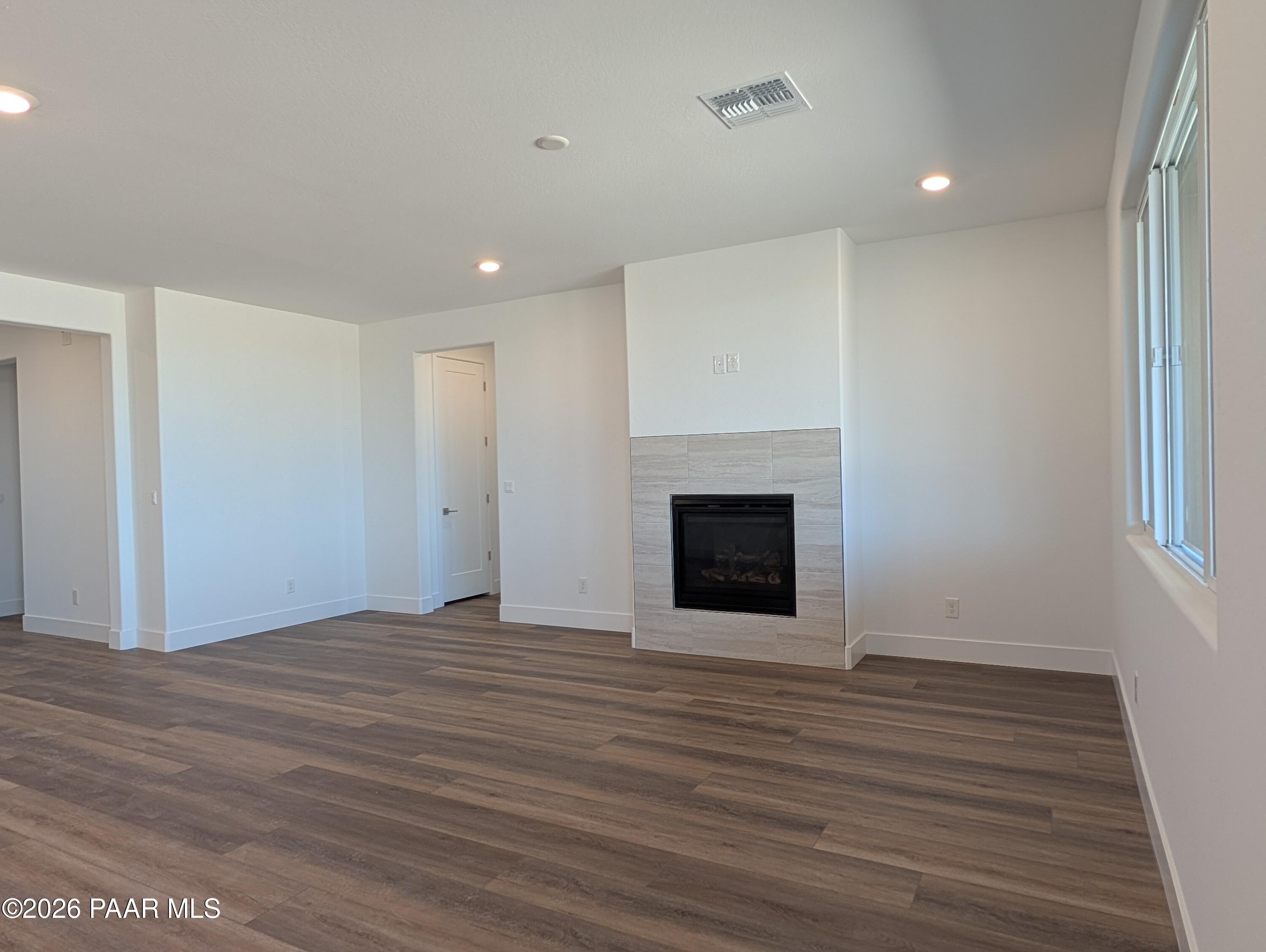 Elegant gas fireplace with stone surround in open living room, luxury vinyl plank floors, Davidson Homes Durango II F, Prescott AZ