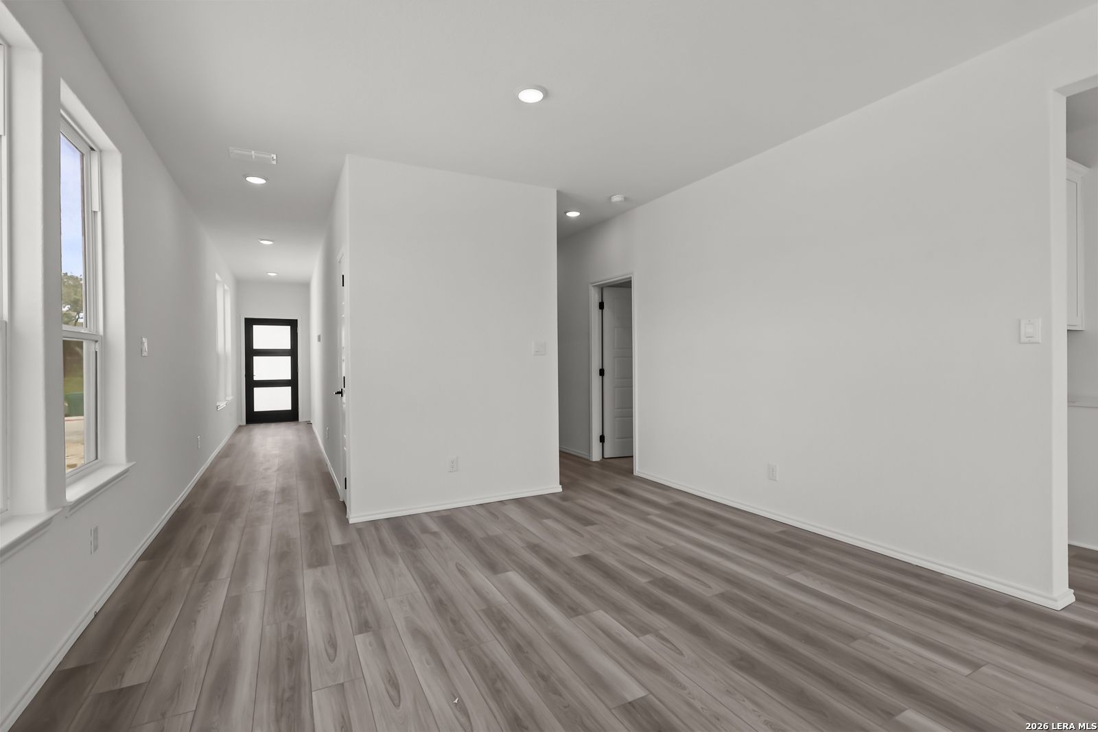 Bright hallway with wood-look flooring in The Florence B floor plan by Davidson Homes in Meadows at Oak Creek, San Antonio.