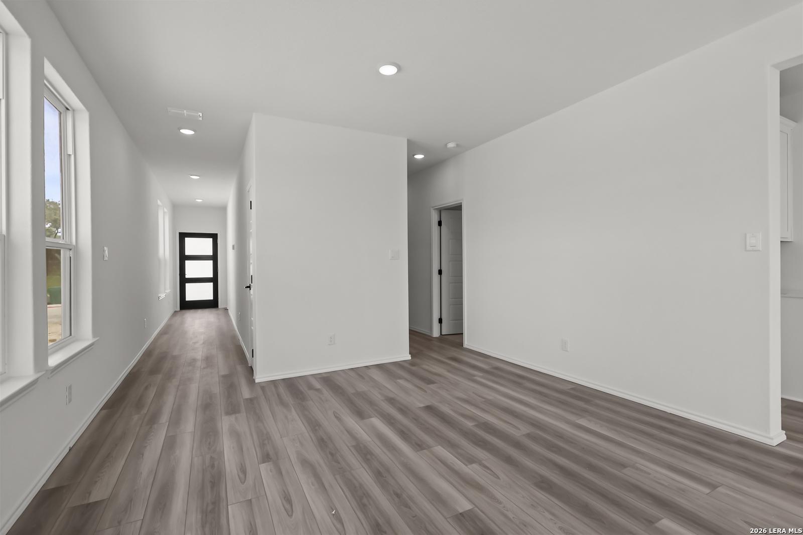 Bright hallway with wood-look flooring in The Florence B floor plan by Davidson Homes in Meadows at Oak Creek, San Antonio.