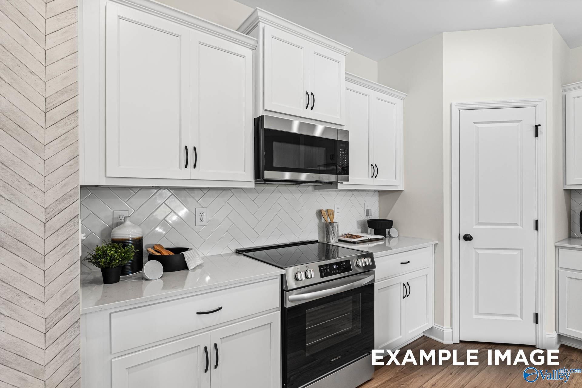Modern white kitchen with stainless steel appliances, subway tile backsplash, and shiplap wall in The Franklin floor plan by Davidson Homes, Huntsville