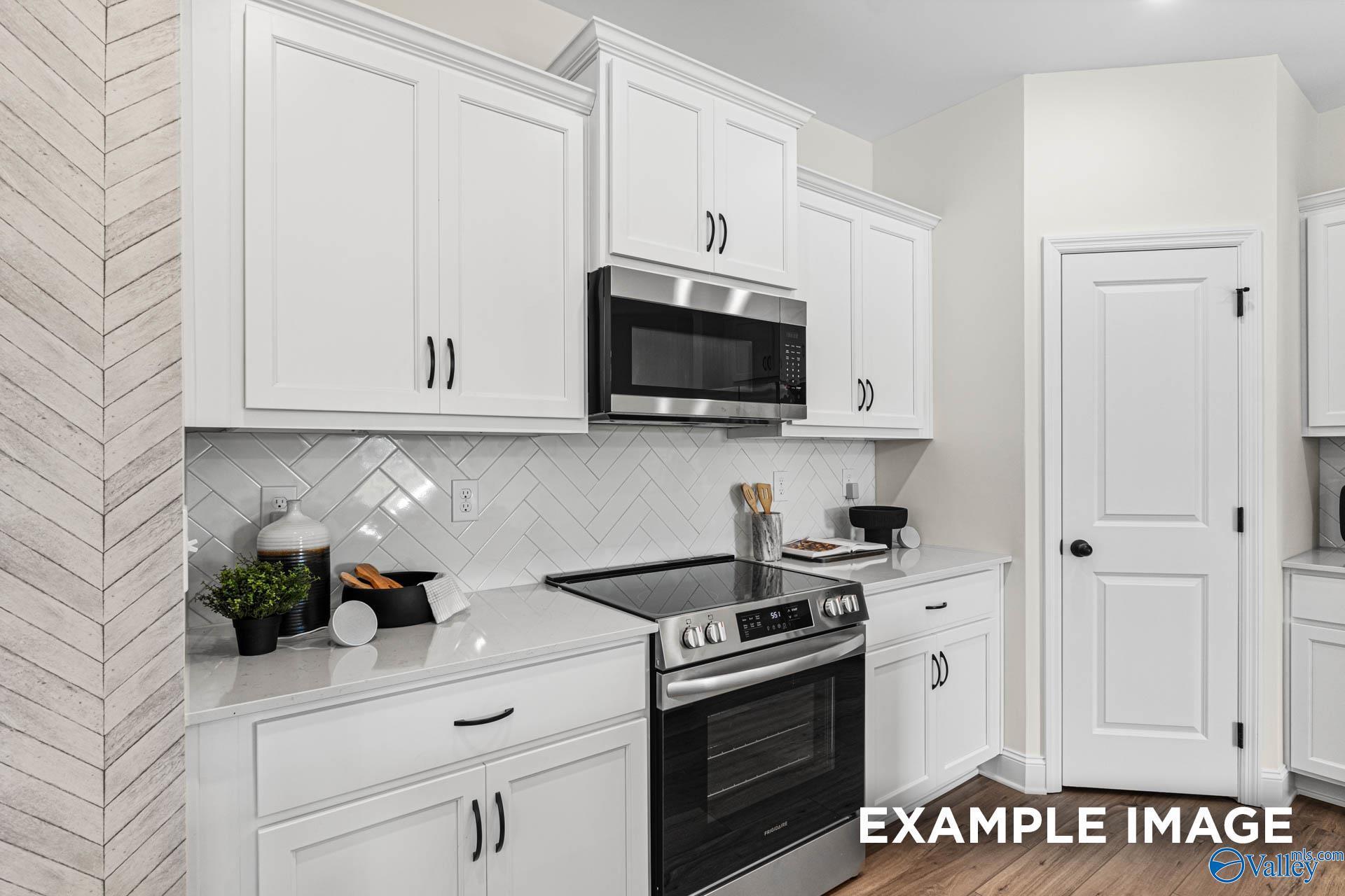 Modern white kitchen with stainless steel appliances, subway tile backsplash, and shiplap wall in The Franklin floor plan by Davidson Homes, Huntsville