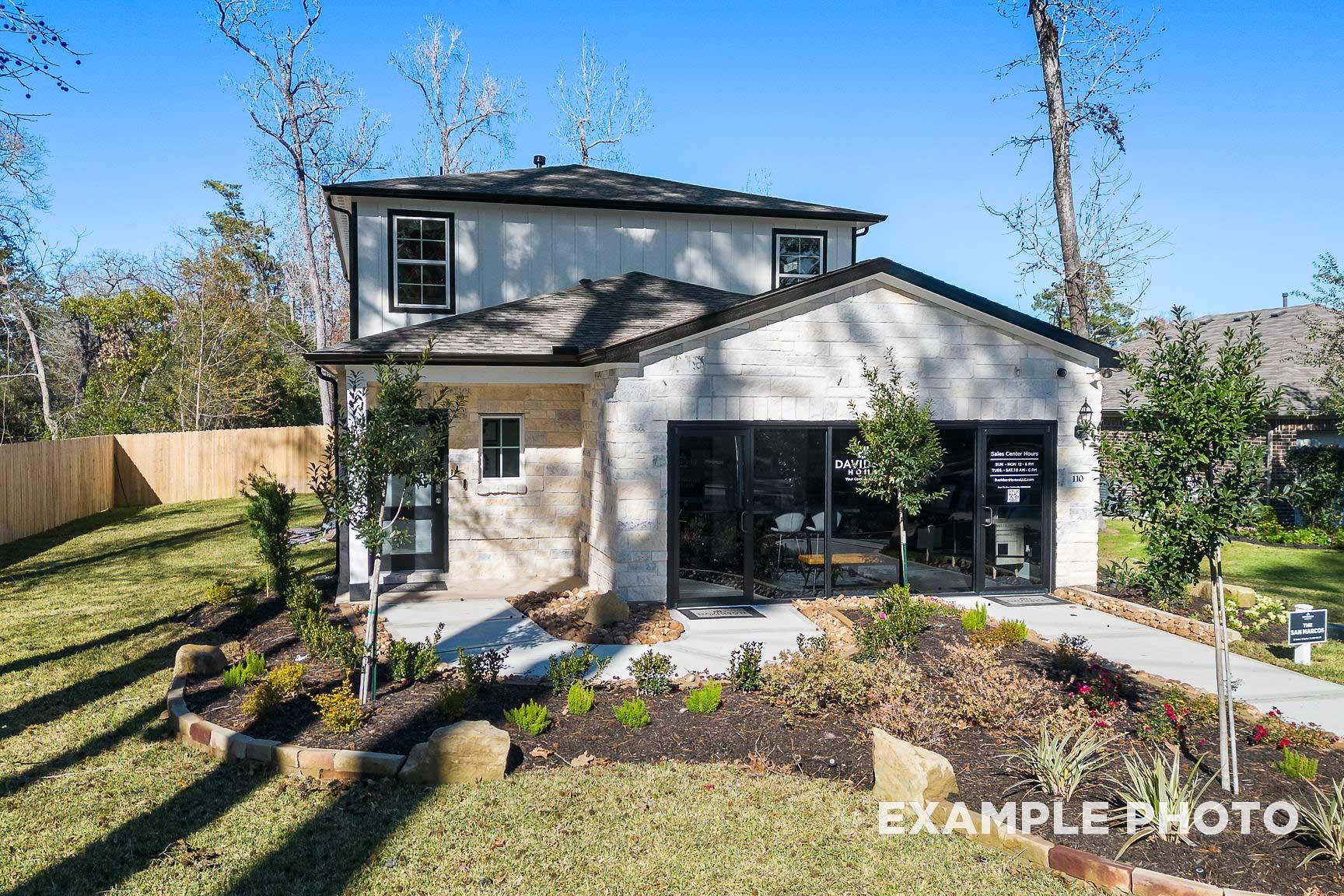 Modern two-story San Marcos home exterior by Davidson Homes in Beasley Texas with white siding, two-car garage, and landscaped front yard