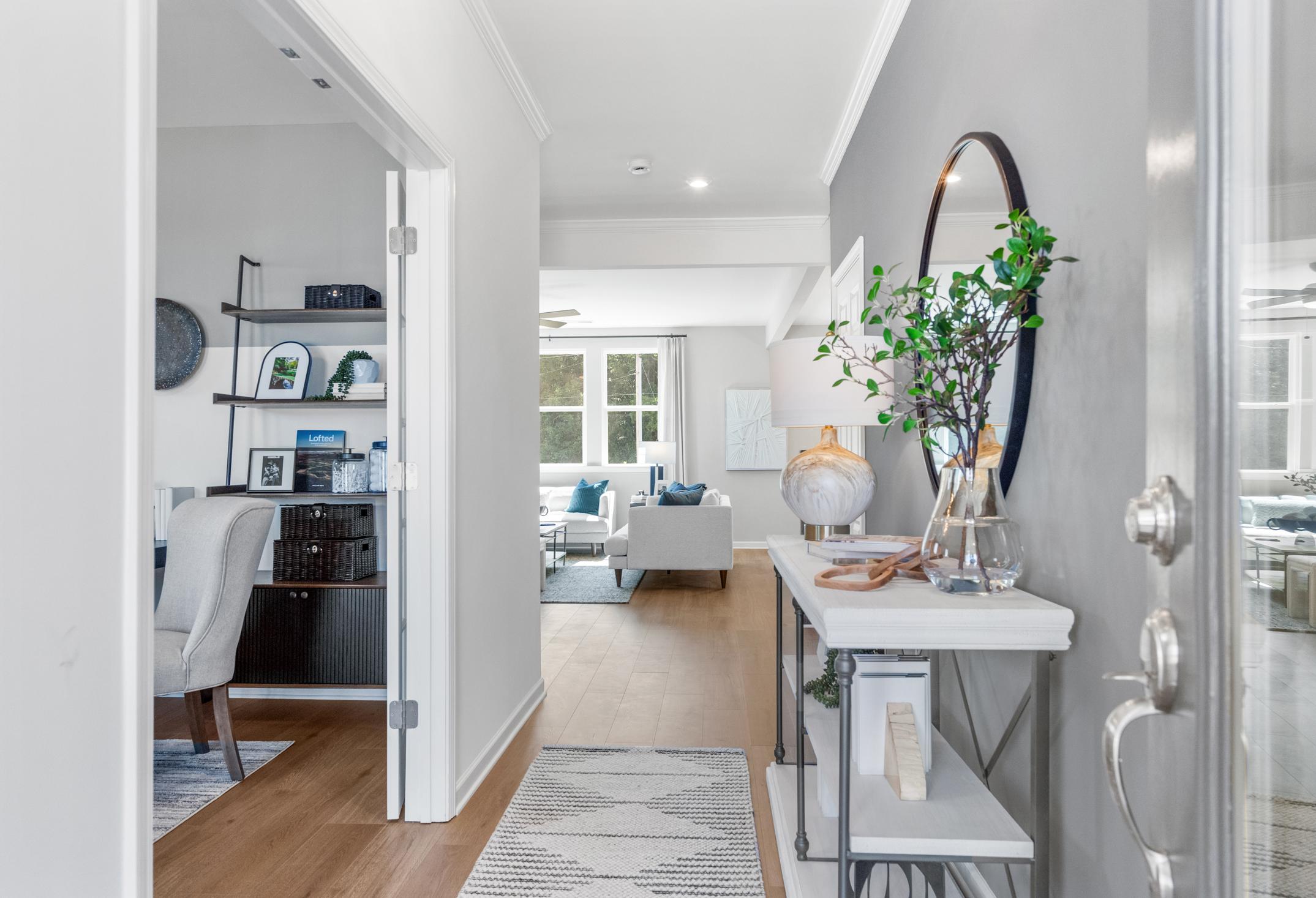 Spacious entry foyer in The Hickory A at Wehunt Meadows with console table, mirror, hallway to home office, and open living room