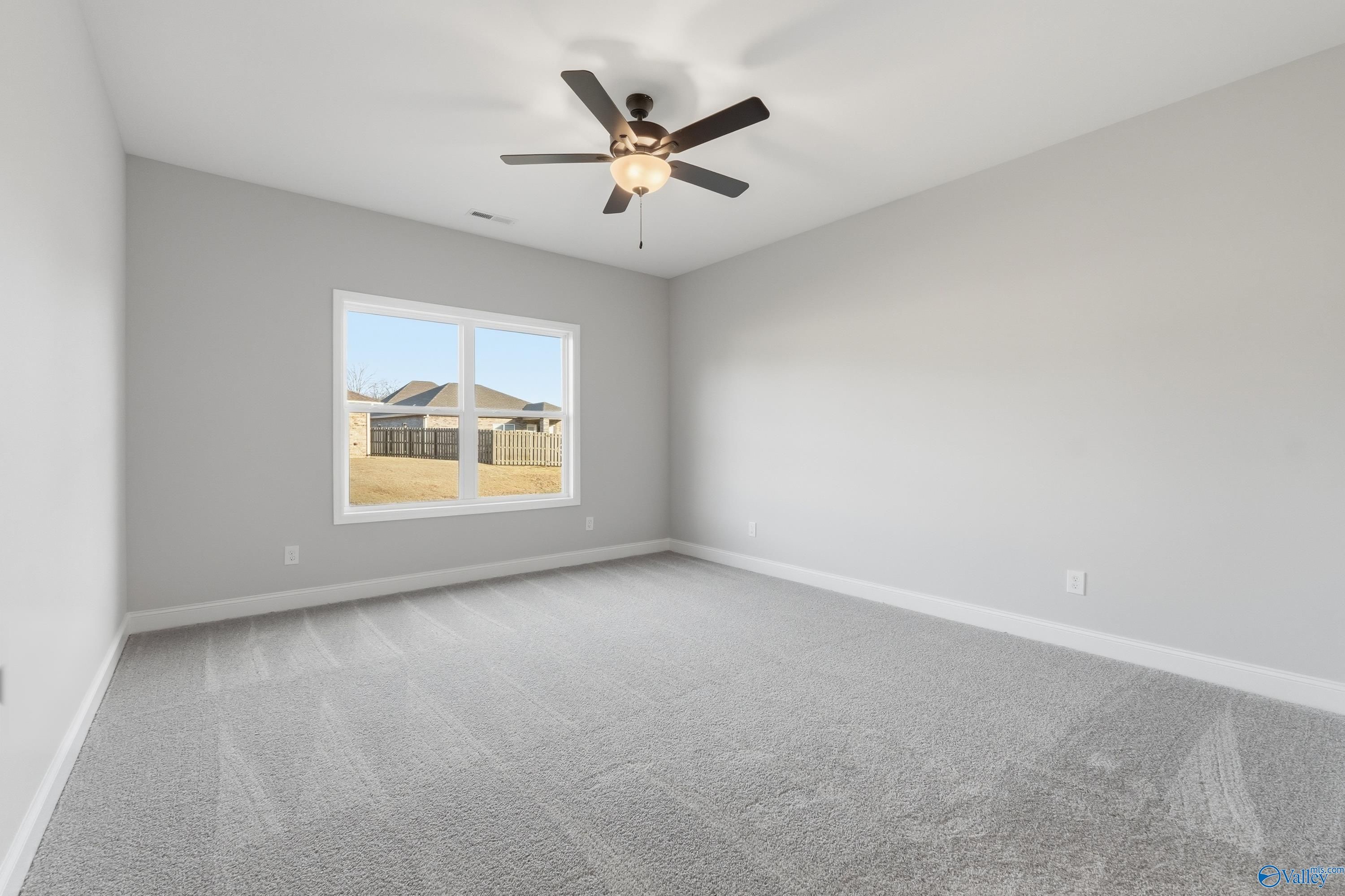 Bright secondary bedroom with ceiling fan, gray walls, and window to backyard in Davidson Homes The Daphne D, Arab, Alabama