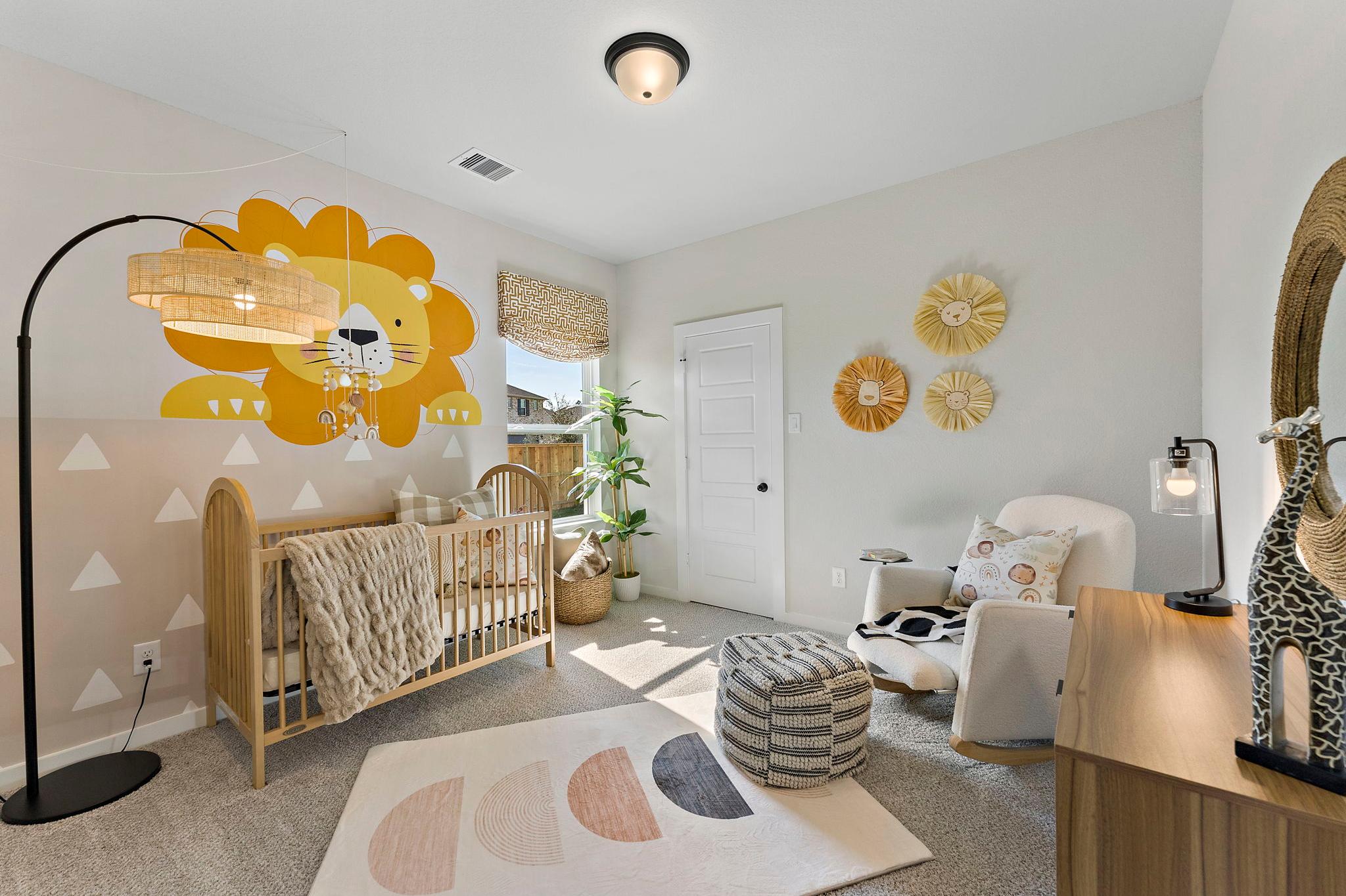 Charming nursery at Sundance Cove in Crosby TX with yellow lion wall decal, wooden crib, woven accents and potted plants