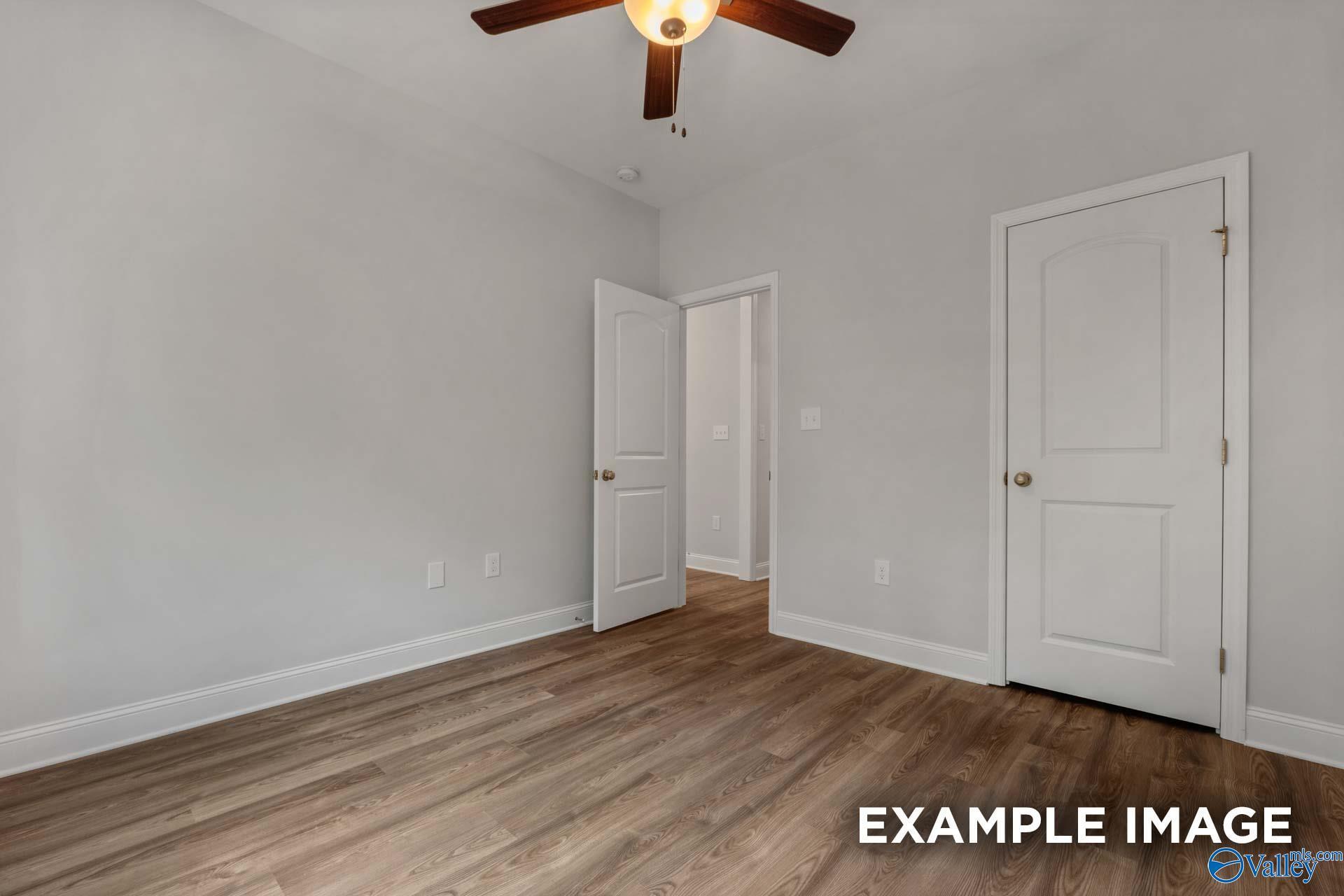 Spacious bedroom with gray walls, hardwood floors, and ceiling fan in Davidson Homes The Shelby C, Arab, Alabama