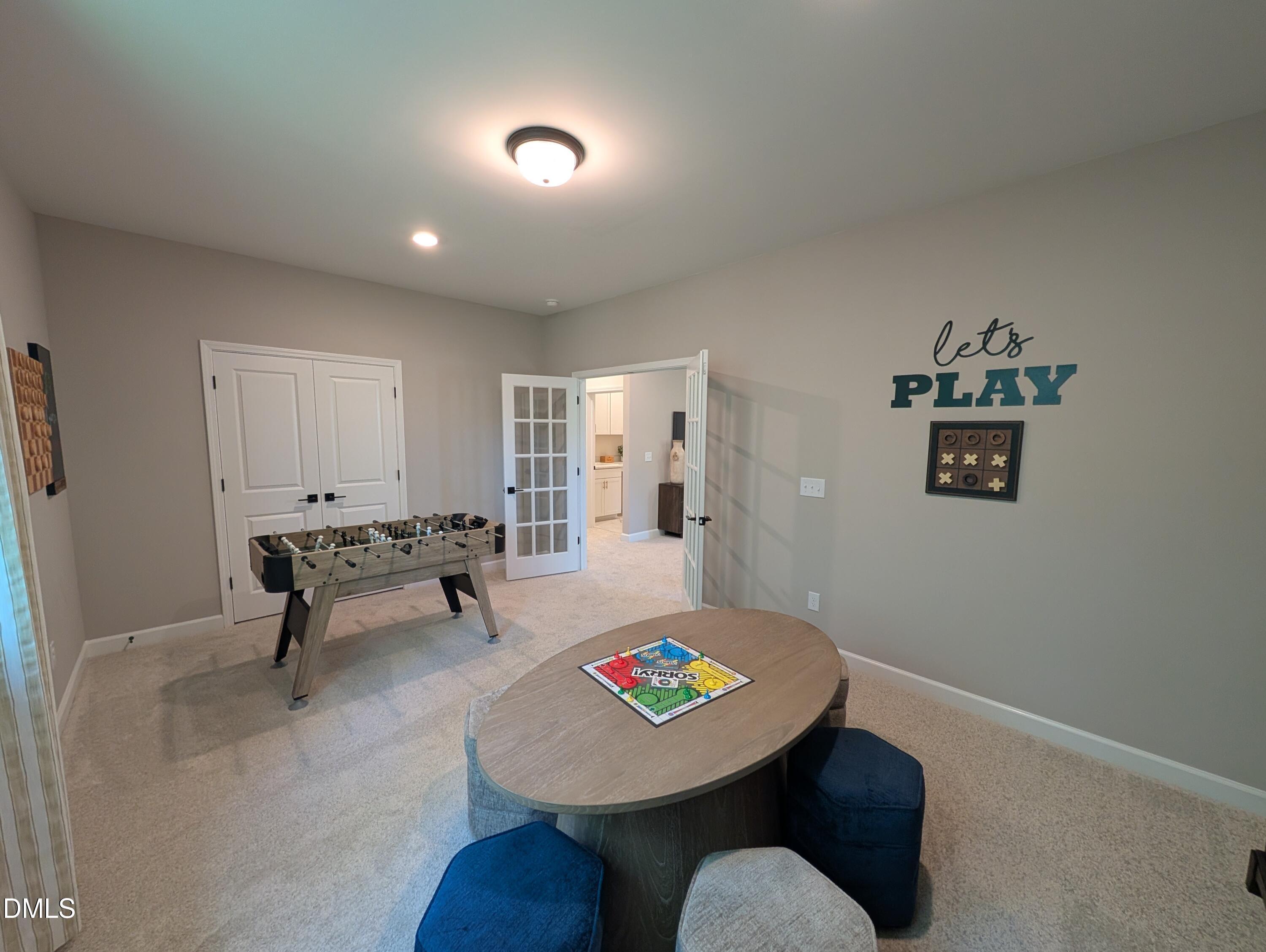 Spacious game room with foosball table and activity table in The Aspen B floor plan at Wendell Ridge, Wendell, NC.