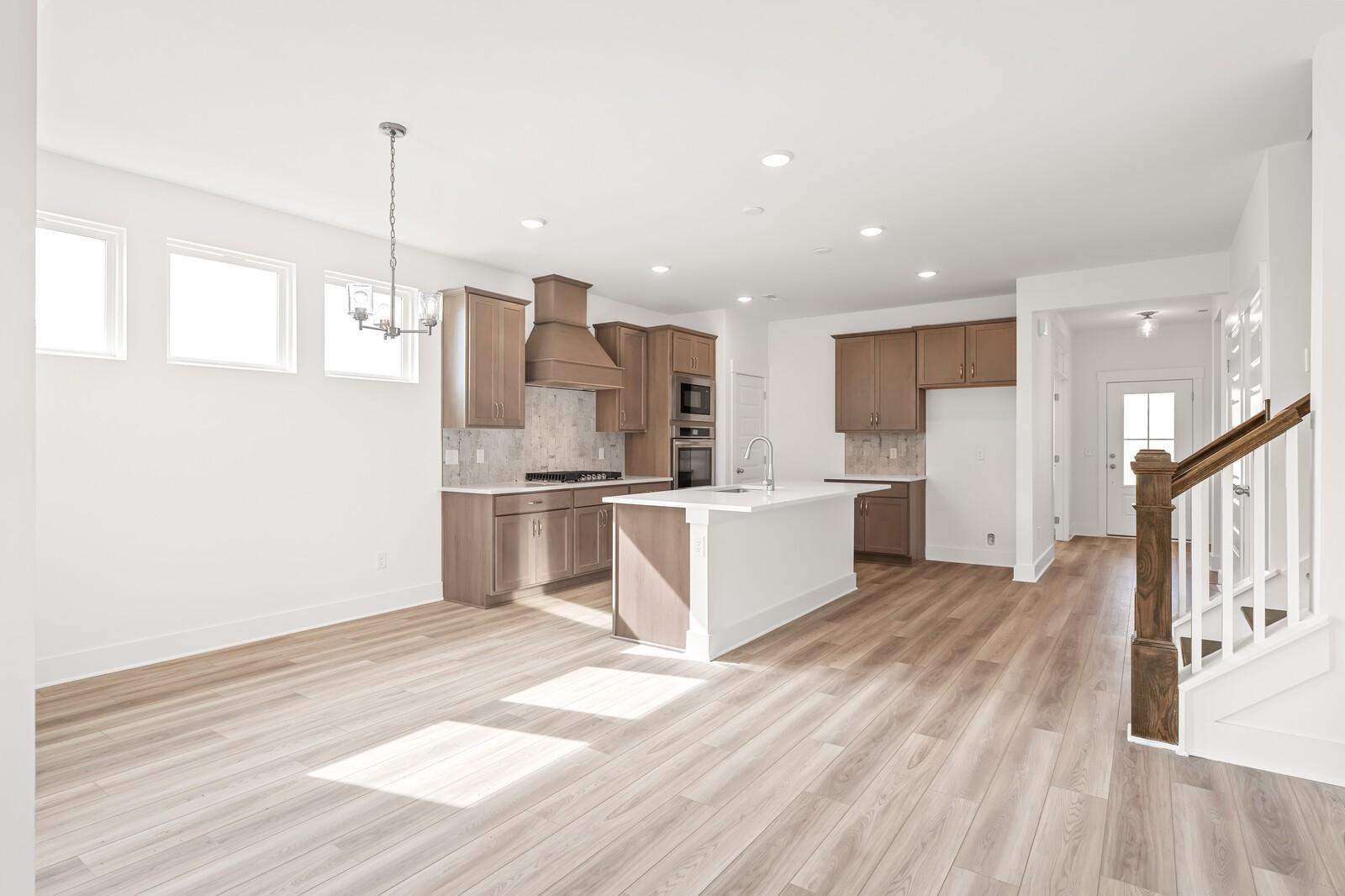 Modern open-concept kitchen with white quartz island, shaker cabinets, stainless appliances in Davidson Homes The Ash C, Mt. Juliet, TN