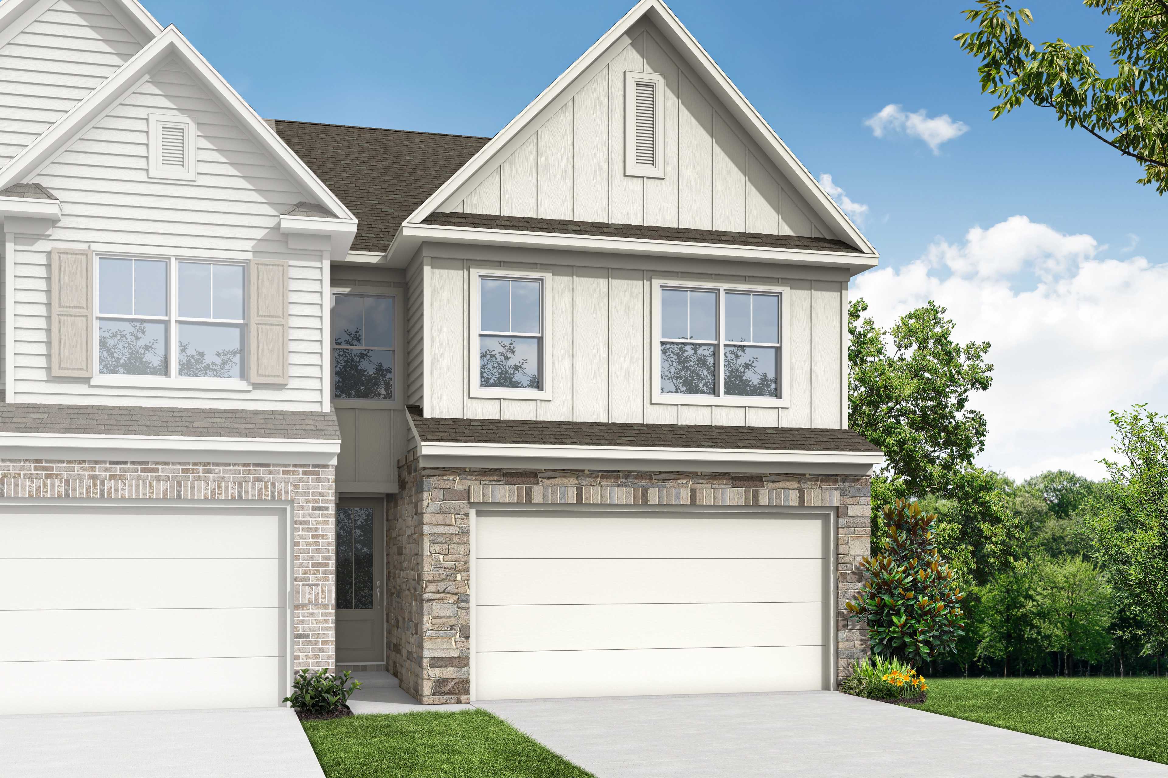 Two-story multi-family home elevation of The Chatham D with white siding, stone accents, 2-car garage, and lush landscaping in Cumming, GA