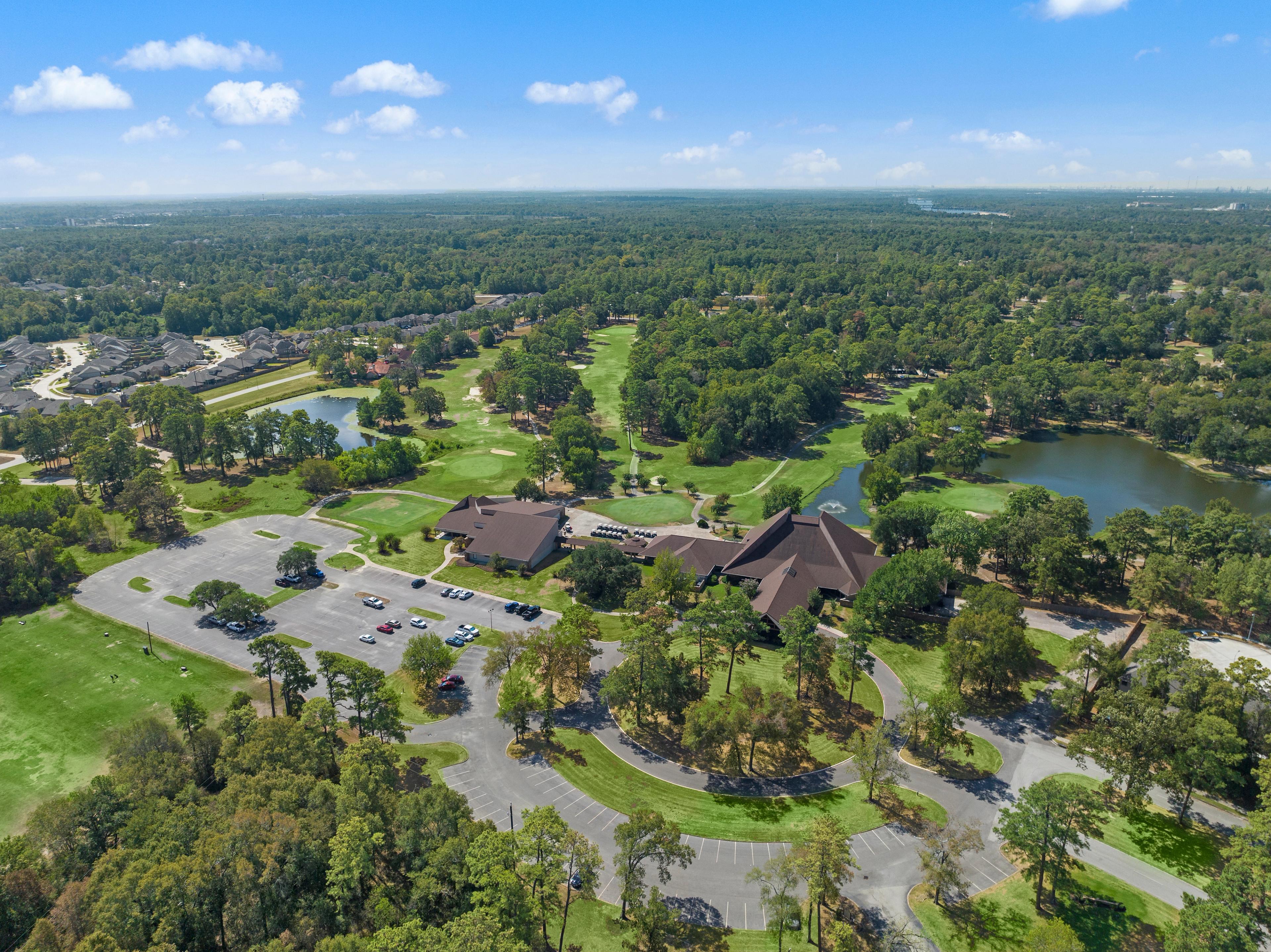 Aerial view of clubhouse pavilion, scenic lake, golf course, and lush greenery at Enclave at Newport in Crosby, Texas by Davidson Homes