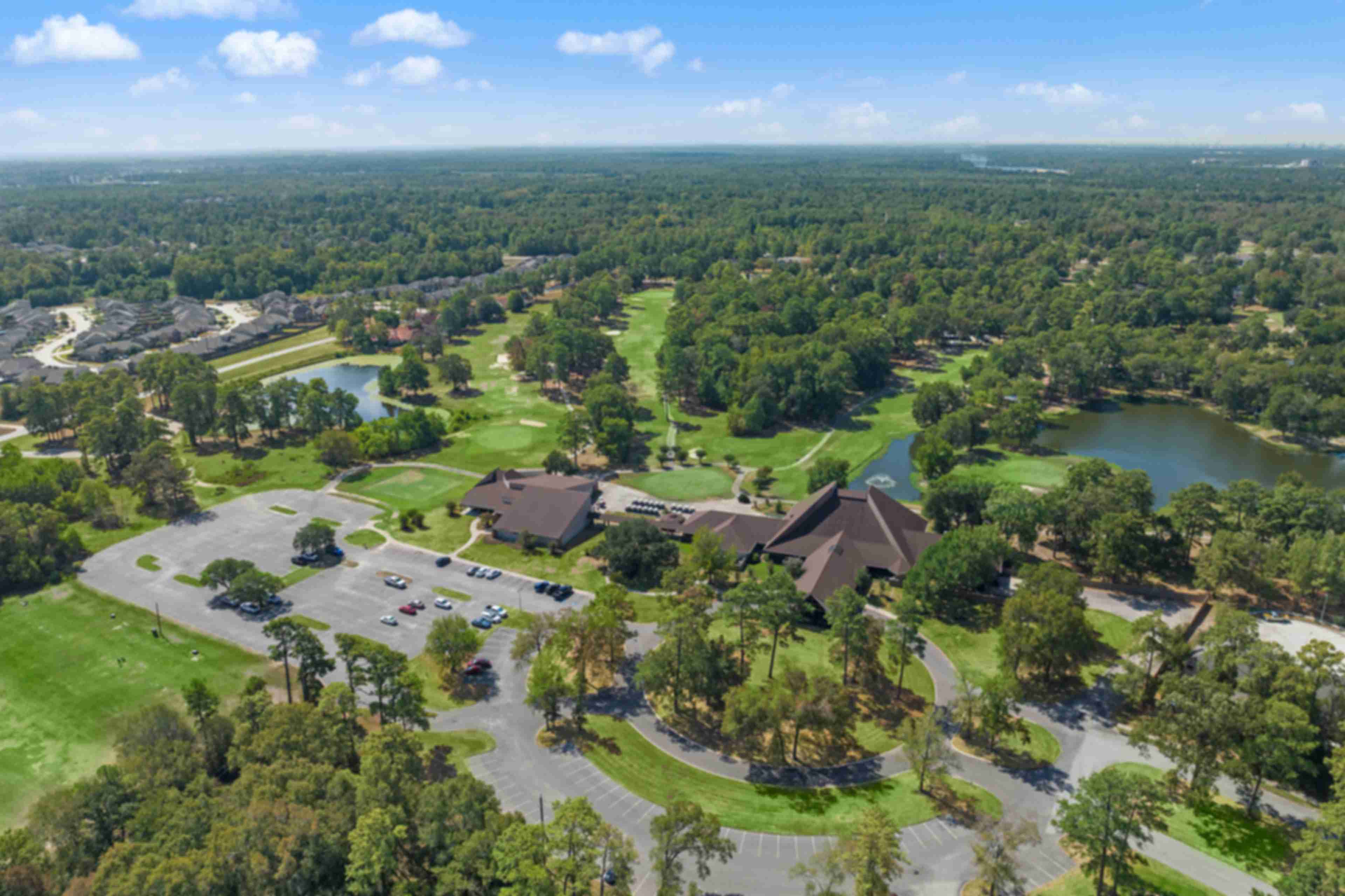 Aerial view of clubhouse pavilion, scenic lake, golf course, and lush greenery at Enclave at Newport in Crosby, Texas by Davidson Homes
