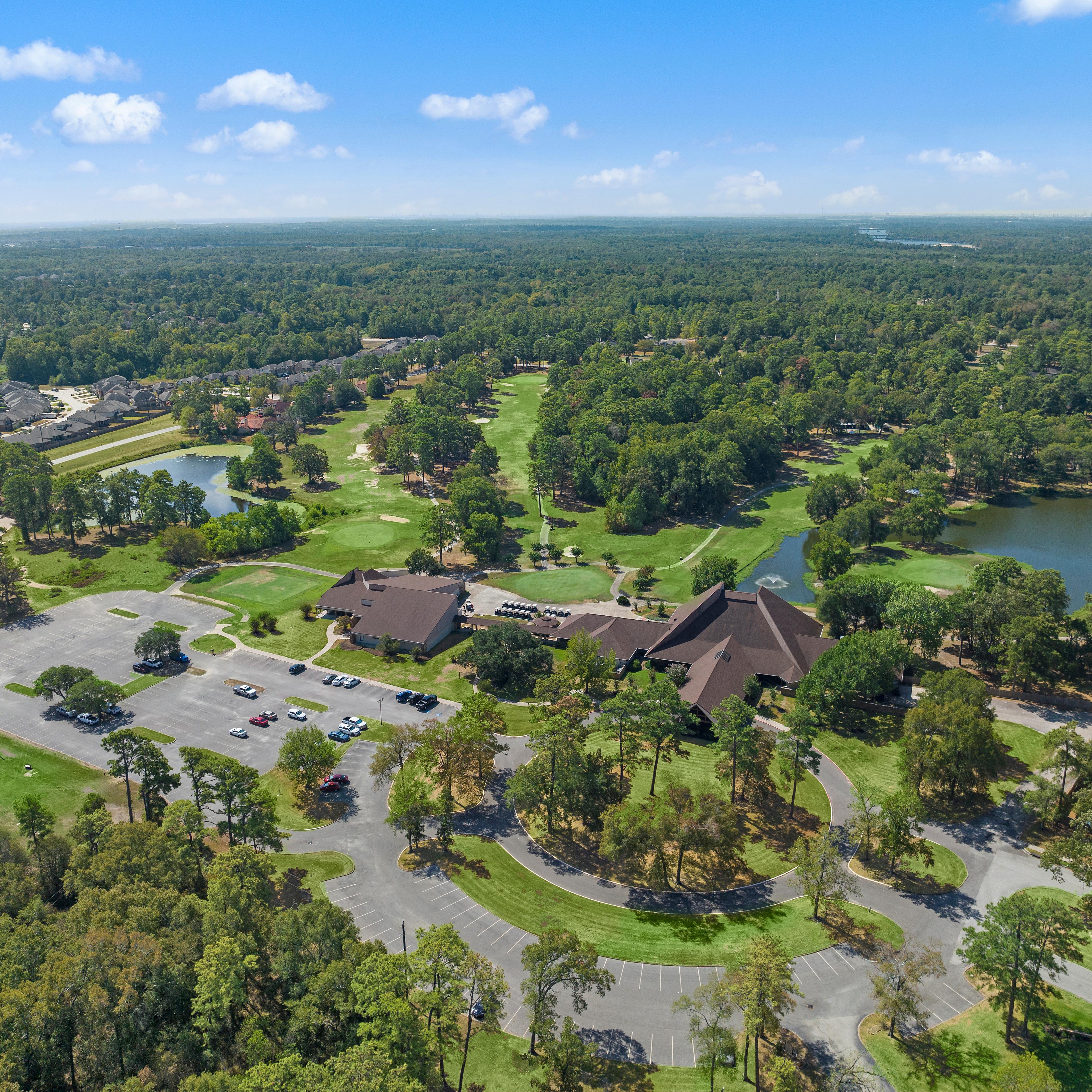 Aerial view of clubhouse pavilion, scenic lake, golf course, and lush greenery at Enclave at Newport in Crosby, Texas by Davidson Homes