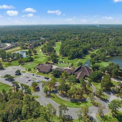 Aerial view of clubhouse pavilion, scenic lake, golf course, and lush greenery at Enclave at Newport in Crosby, Texas by Davidson Homes