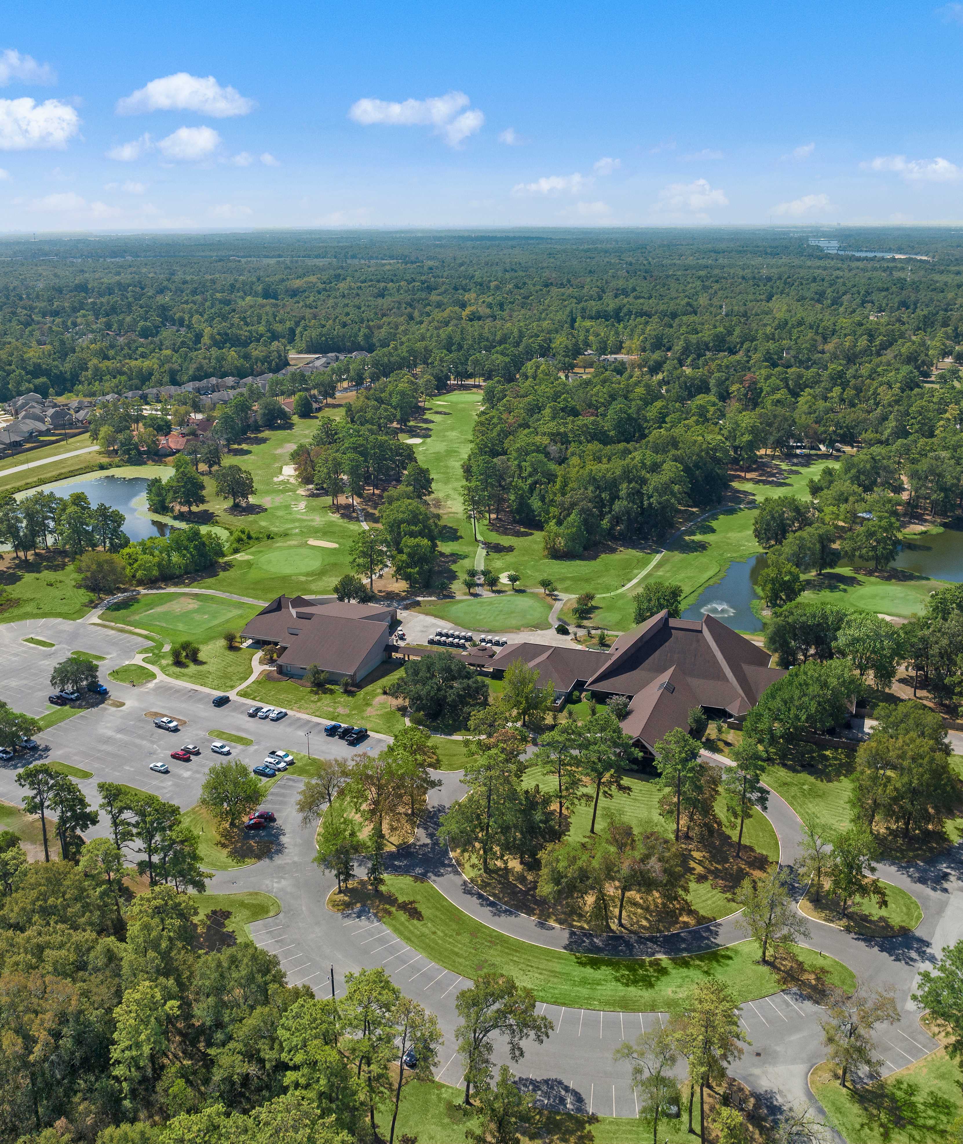 Aerial view of clubhouse pavilion, scenic lake, golf course, and lush greenery at Enclave at Newport in Crosby, Texas by Davidson Homes