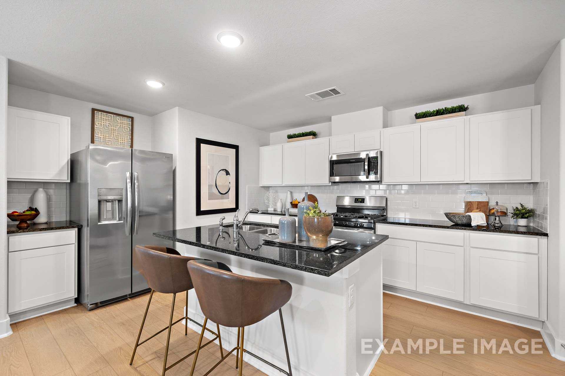 Modern kitchen in The Rose B Davidson Homes design with white shaker cabinets, black granite island, stainless steel appliances