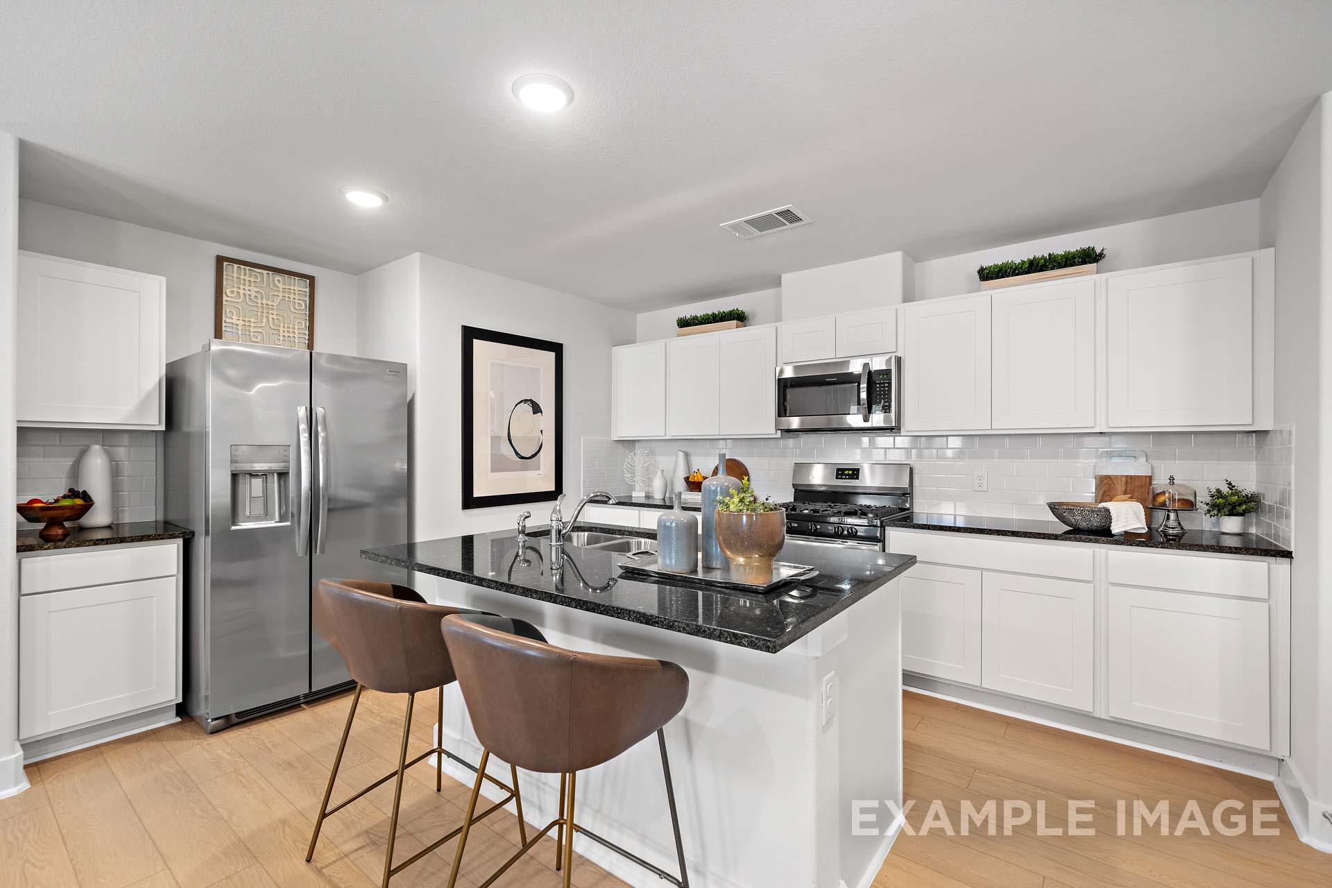 Modern kitchen in The Rose B Davidson Homes design with white shaker cabinets, black granite island, stainless steel appliances