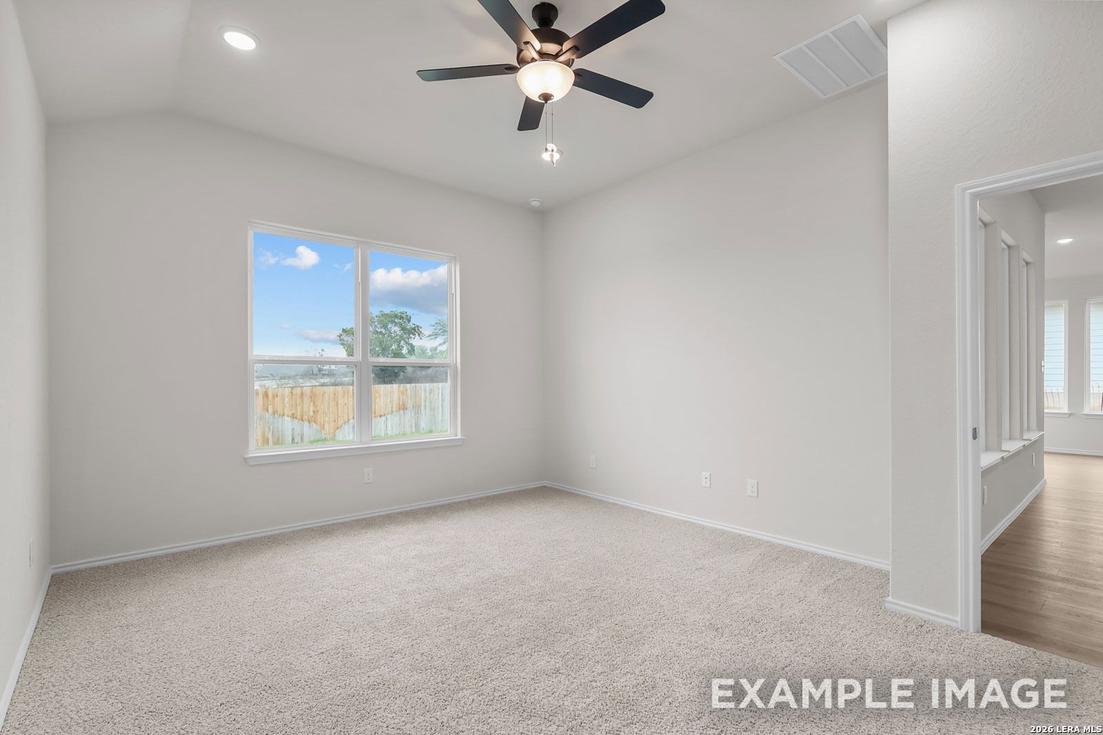 Bright bedroom with vaulted ceiling and ceiling fan in The Sequoia C floor plan, Royal Crest, San Antonio, Texas.