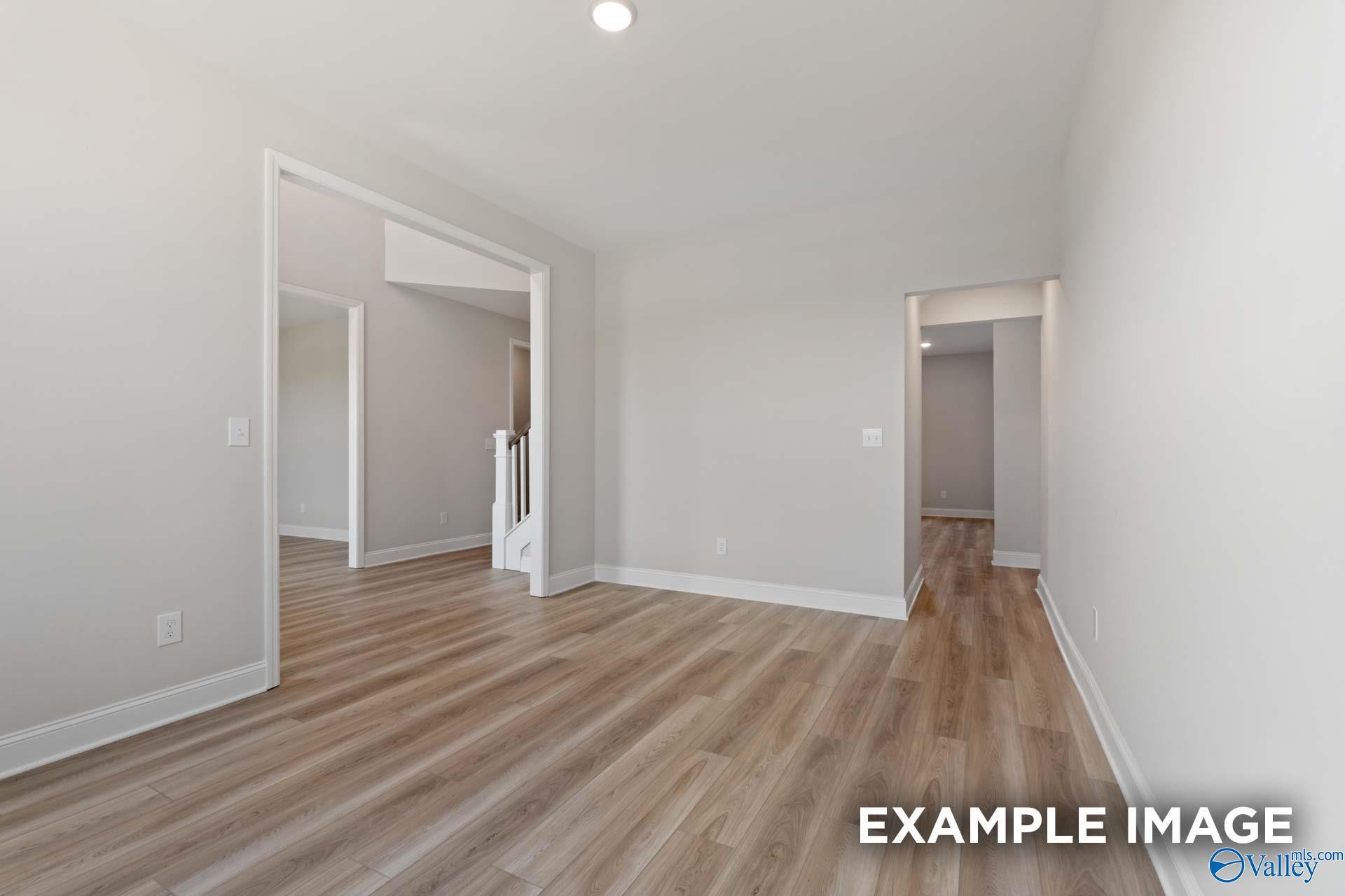 Spacious foyer with light wood floors, arched entryways, and staircase in 5-bedroom Davidson Homes The Madison A, Toney Alabama