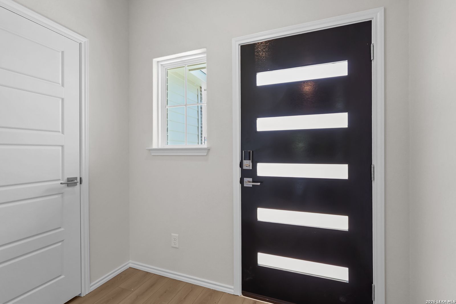 Modern black front door with horizontal glass panels in The San Marcos F floor plan by Davidson Homes in San Antonio, TX.