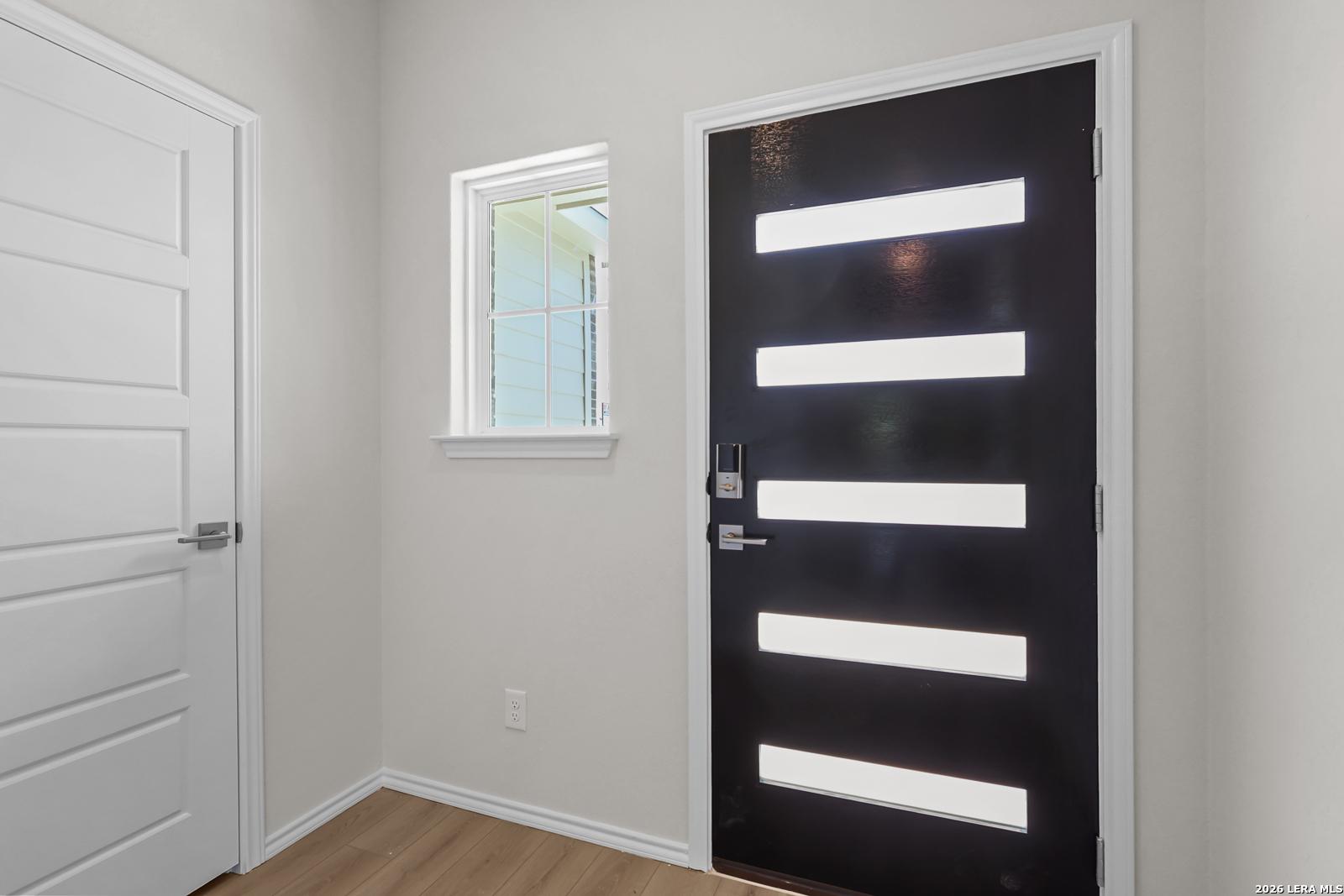 Modern black front door with horizontal glass panels in The San Marcos F floor plan by Davidson Homes in San Antonio, TX.
