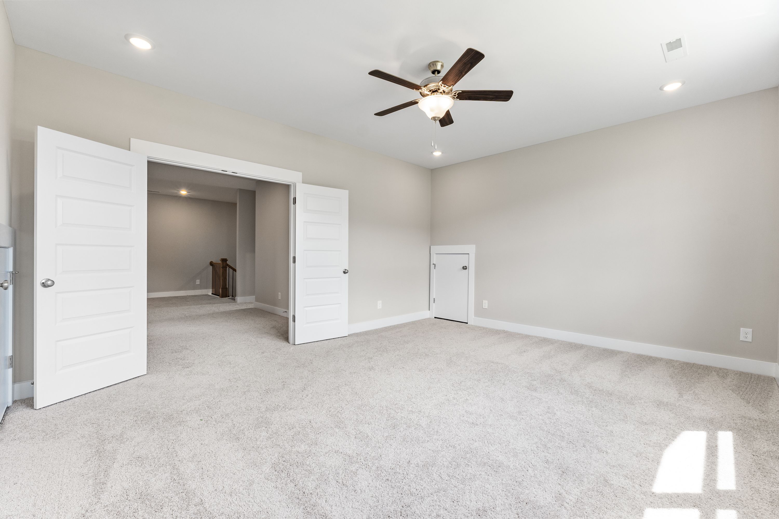 Spacious entryway in The Oxford A home with open double doors, beige carpeted floor, ceiling fan, and neutral walls