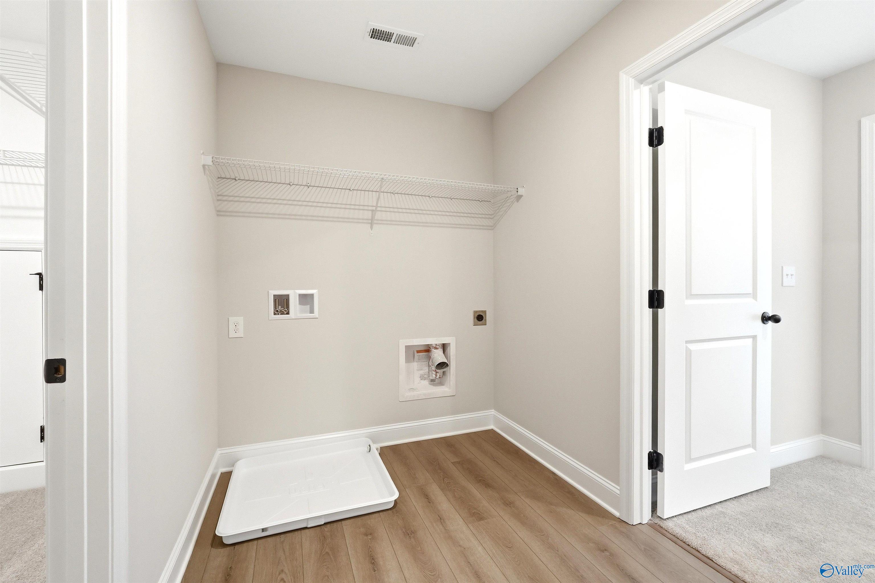 Laundry room with wire shelving and durable flooring in The Chelsea D floor plan by Davidson Homes, New Market, AL.