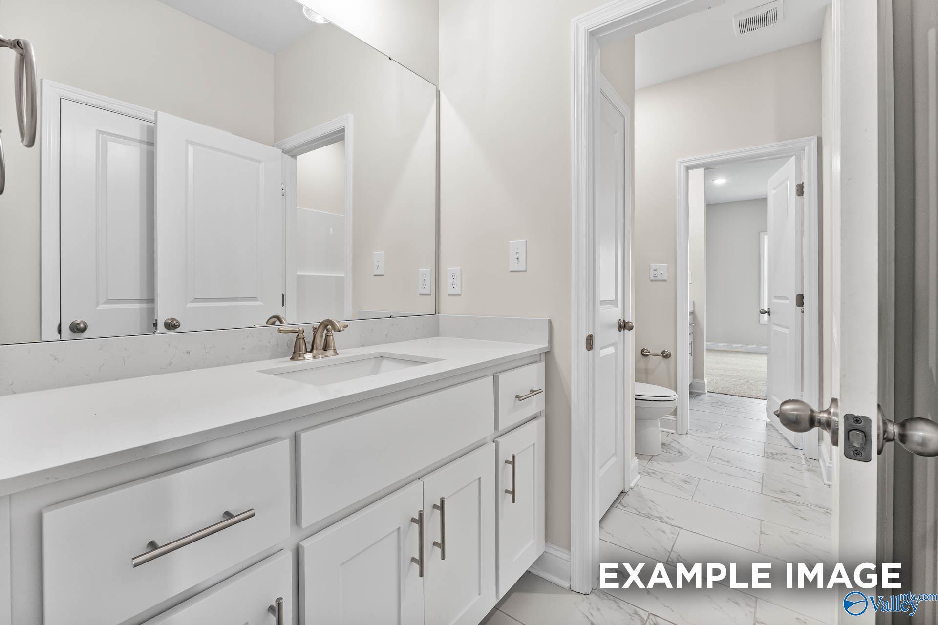 Contemporary bathroom with white shaker vanity, undermount sink, and tiled floor in Davidson Homes The Finleigh, Huntsville Alabama