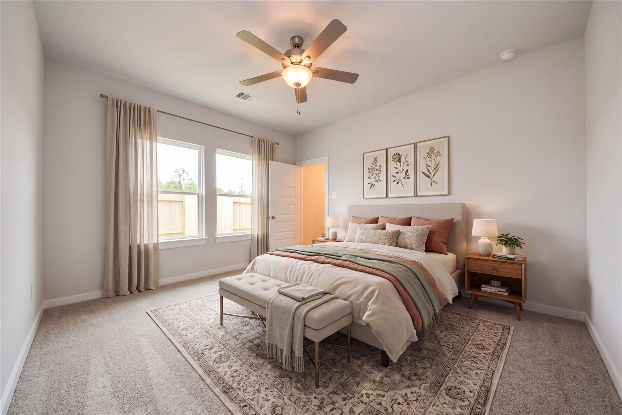 Bright primary bedroom with ceiling fan, neutral bedding, and large windows in Davidson Homes' The Blanco E, Dayton, Texas