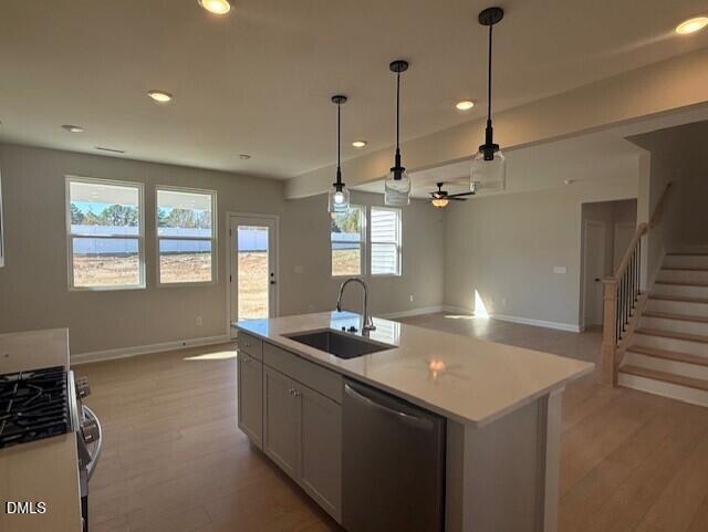 Modern open-concept kitchen with white quartz island, stainless sink, and pendant lights in The Willow D home, Zebulon, NC
