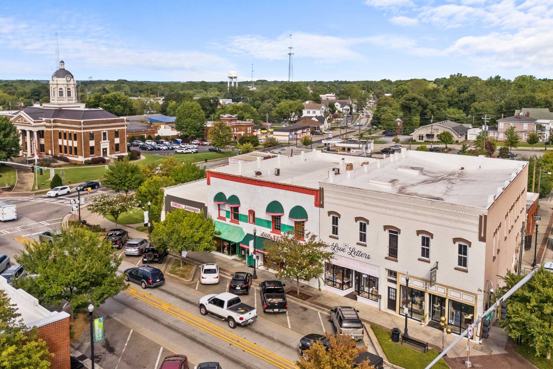 Aerial view of historic downtown Winder Georgia near Lake Shore community featuring domed courthouse, brick storefronts, and tree-lined streets