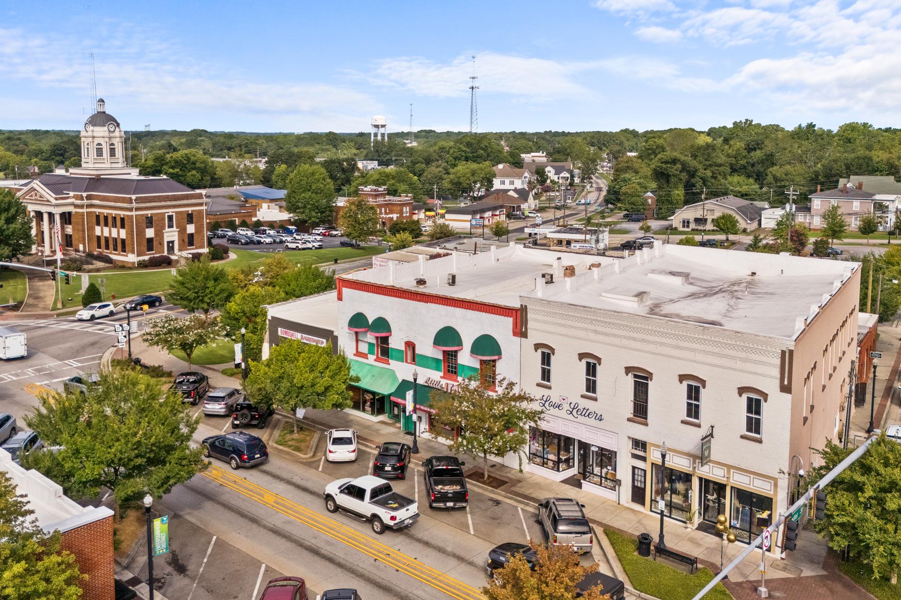 Aerial view of historic downtown Winder Georgia near Lake Shore community featuring domed courthouse, brick storefronts, and tree-lined streets