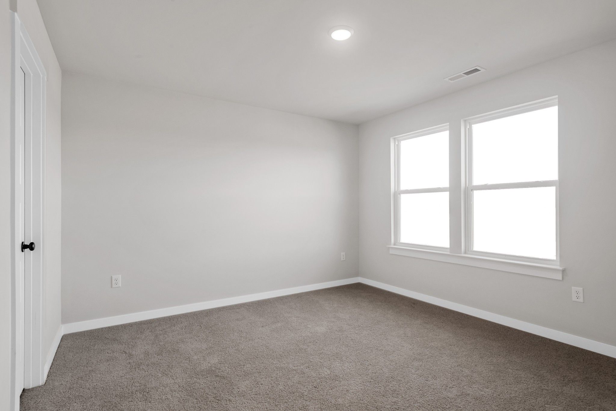 Bright secondary bedroom with light gray walls, neutral carpet, large double windows in Davidson Homes The Willow B, Calista Farms, White House, TN