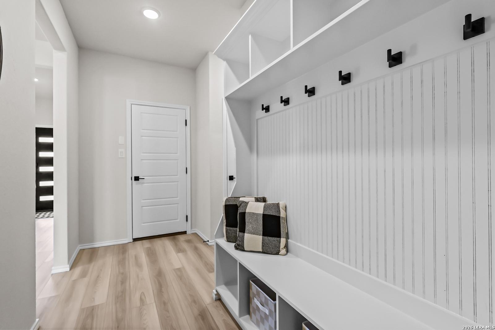 Built-in mudroom bench with storage and coat hooks in The Douglas C floor plan at Hannah Heights, Seguin, Texas.