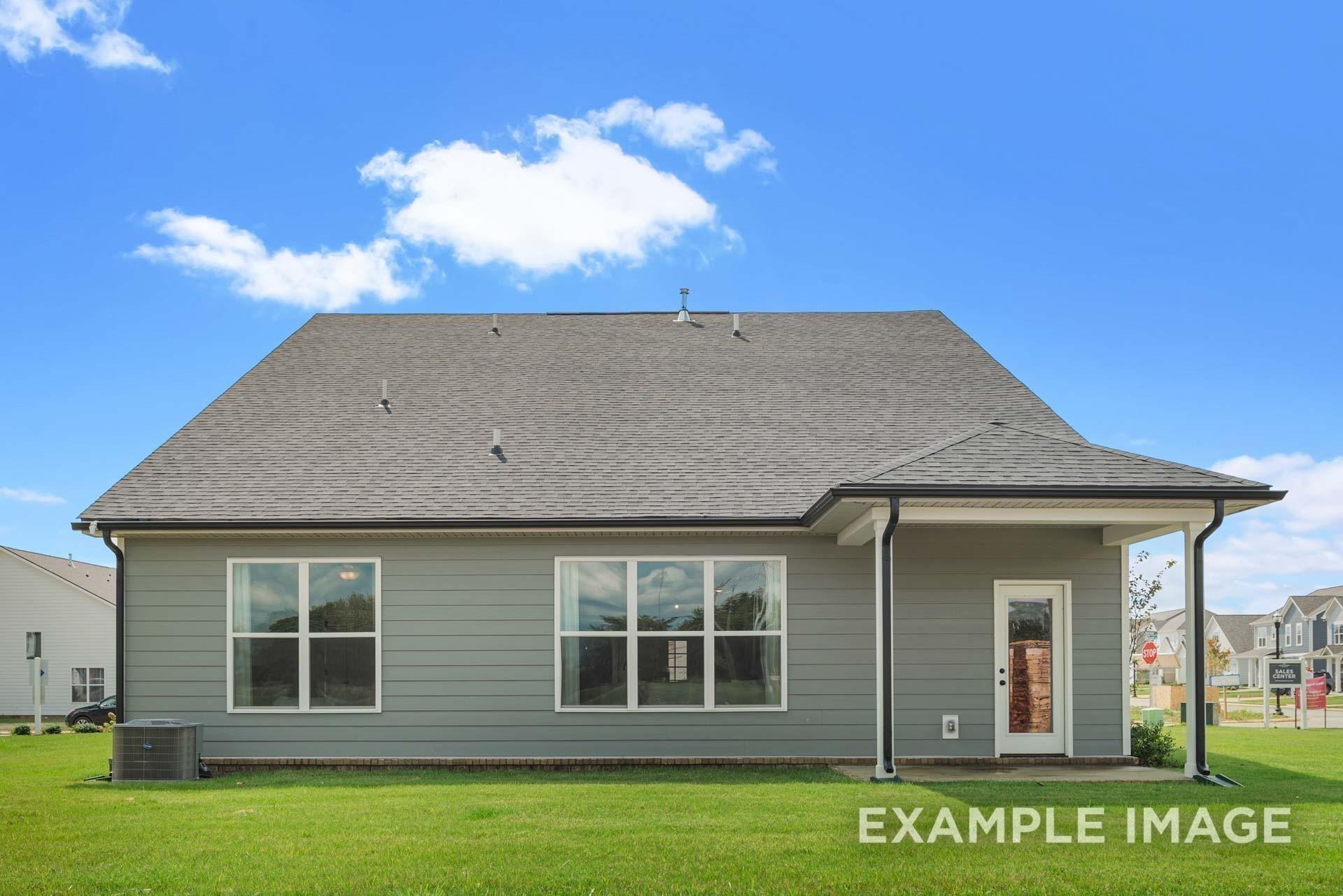 Two-story Ridgeport home rear exterior with covered patio, gray siding, large windows, and green lawn in Woods Crossing, Gallatin, Tennessee