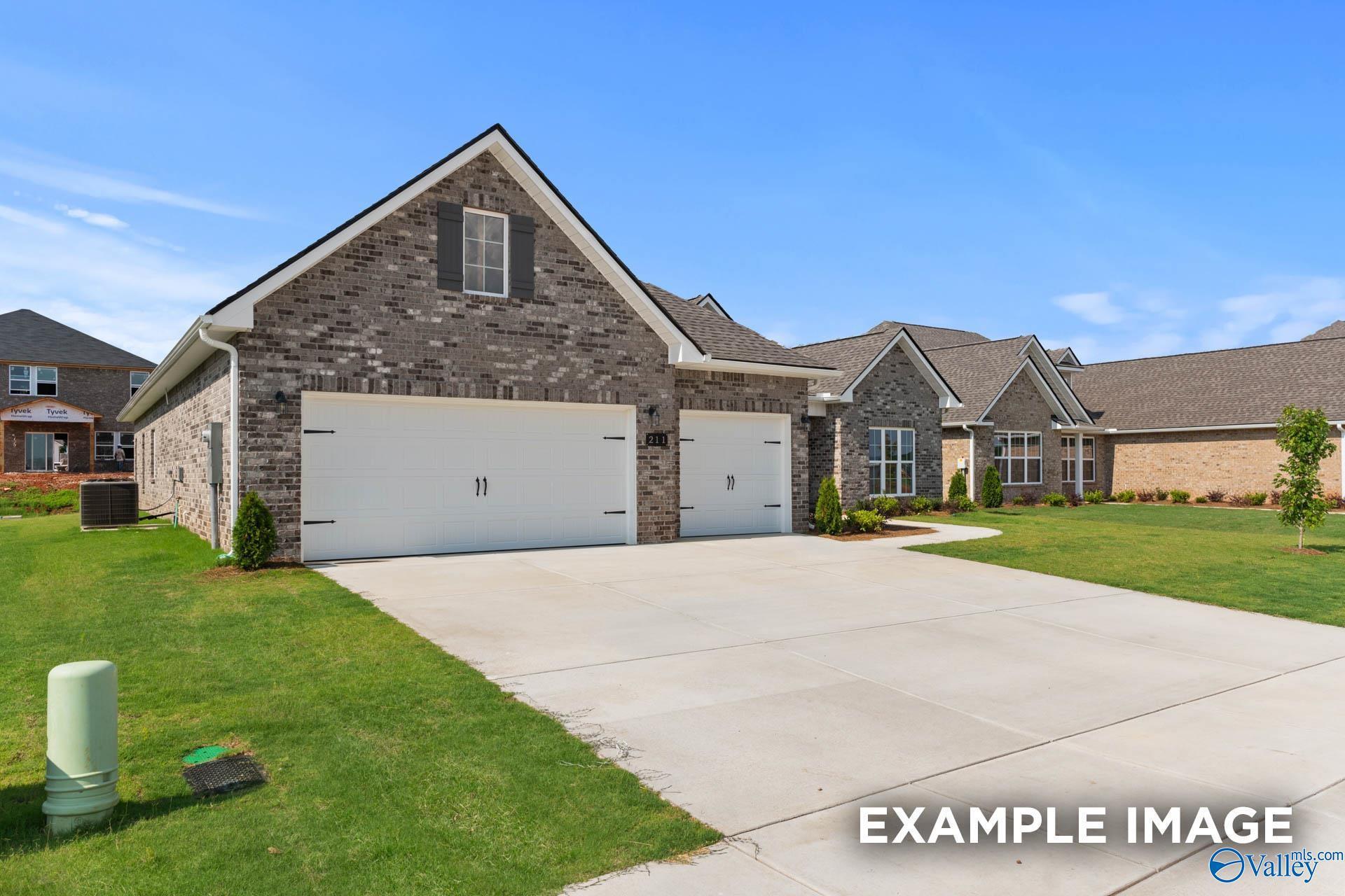 Stylish gray brick 1-story home with gabled roof, 3-car garage, and manicured lawn in Riverton Preserve, Huntsville, Alabama