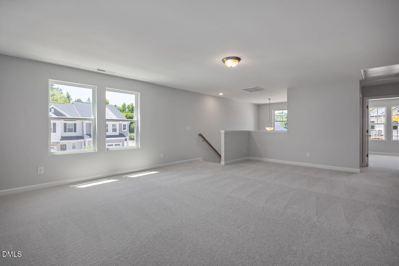 Spacious carpeted loft area in The Adalynn B floor plan by Davidson Homes in Gregory Village, Lillington, North Carolina.